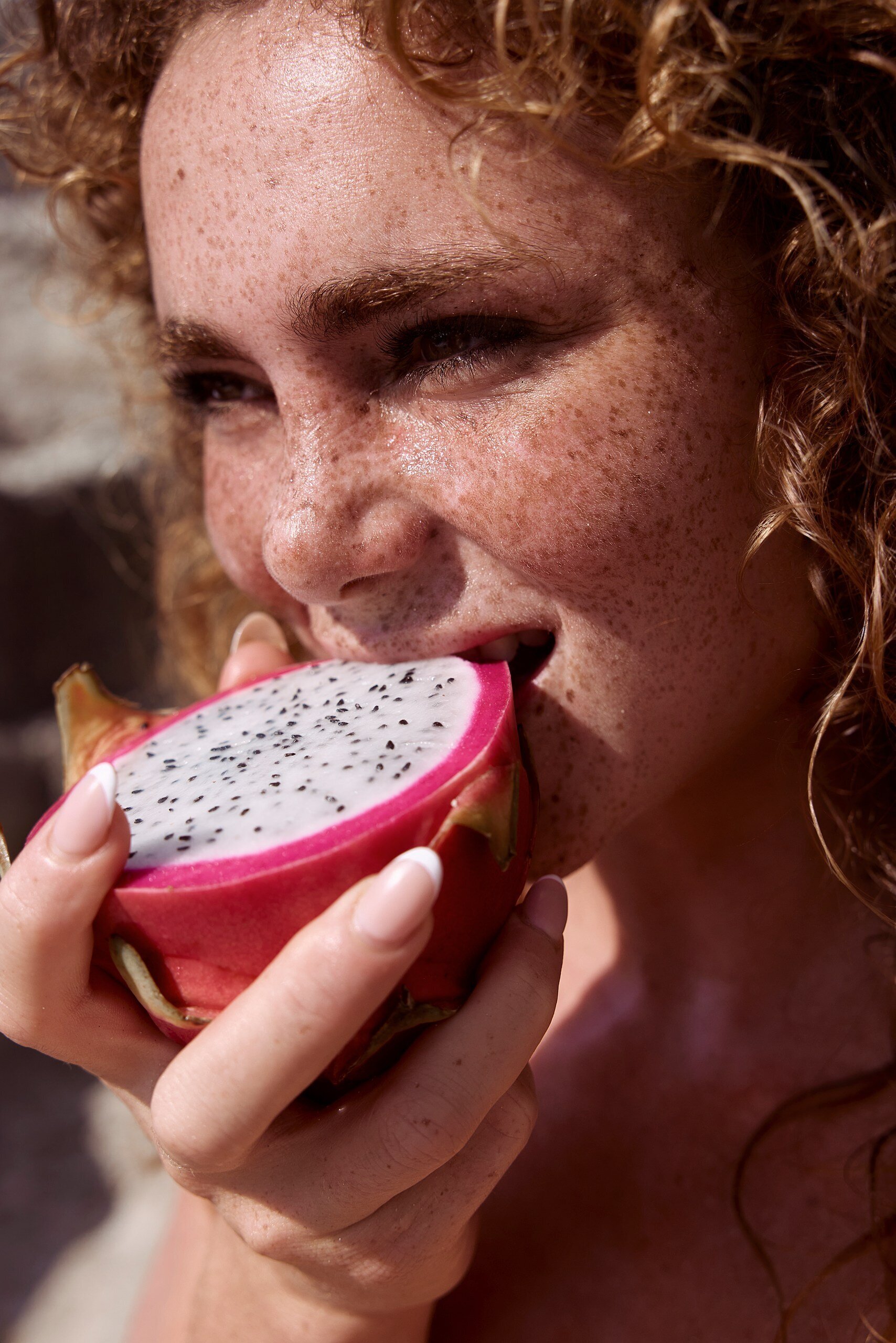 beauty image of red-hair model on beach with dragon fruit