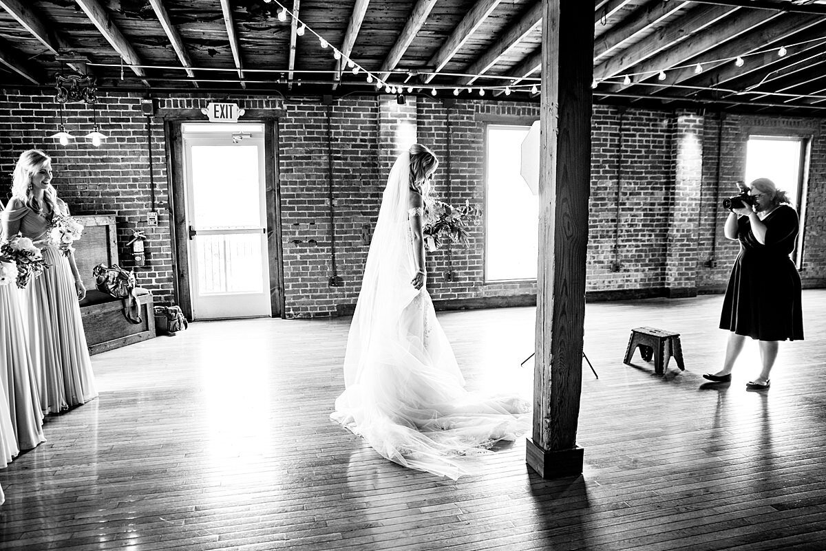 Black and White photo behind the scenes with a photographer on the wedding day