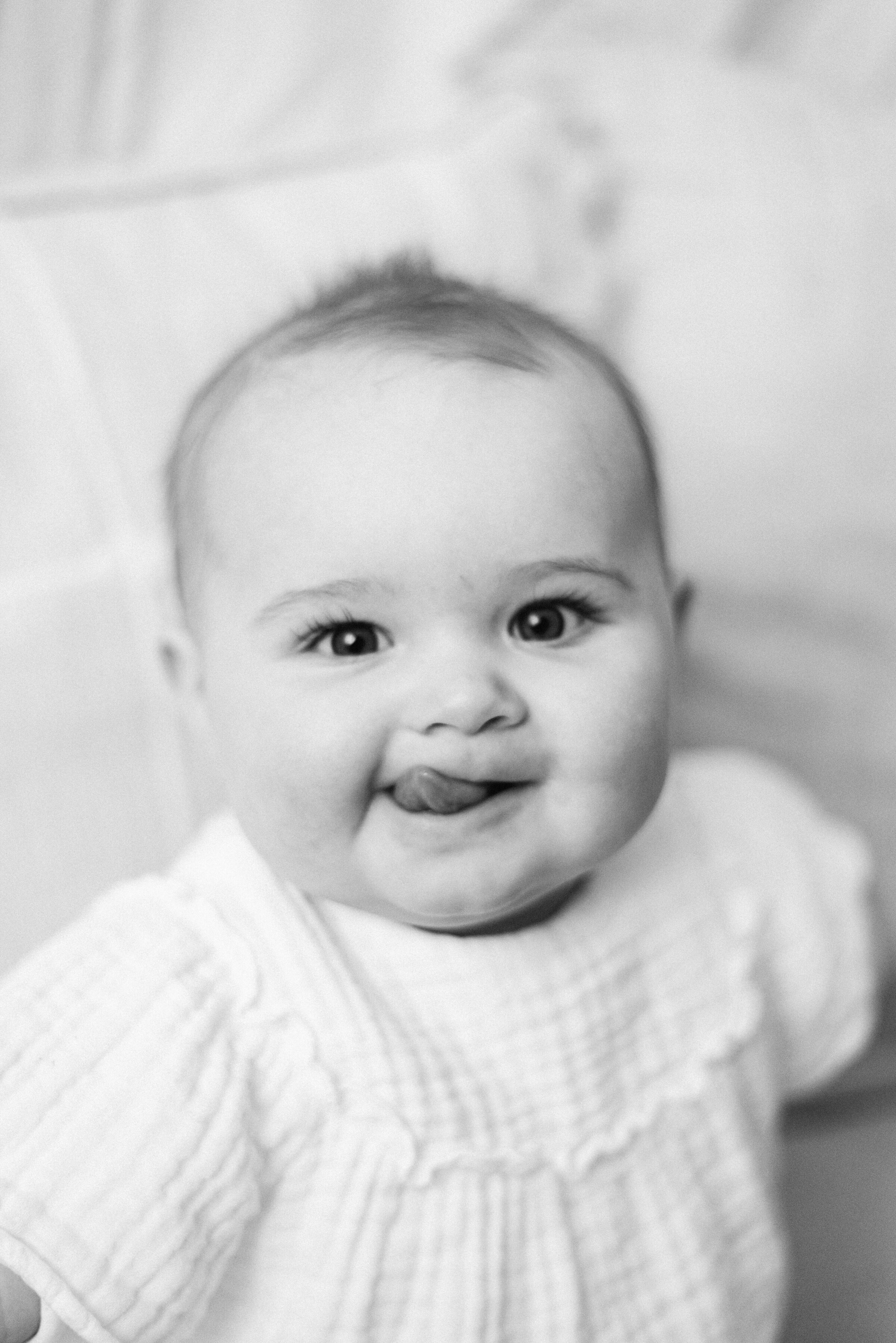 Little girl sticking her tongue out at milestone photoshoot in Billingshurst