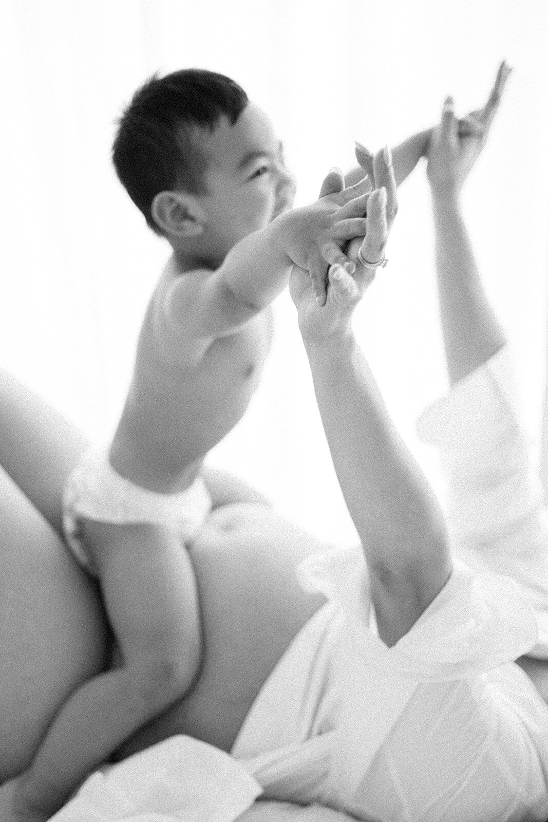 toddler sitting on mums pregnant belly