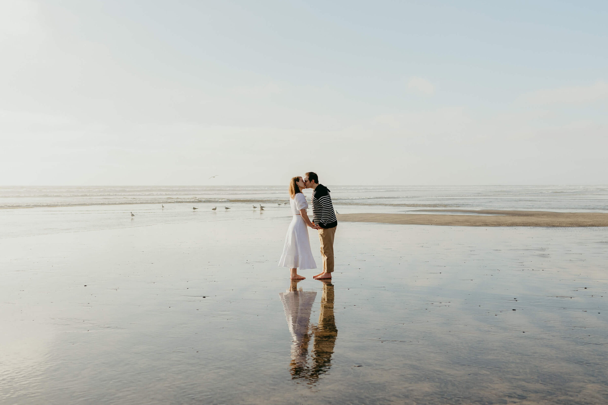 Couple kissing during engagement photos at Torrey Pines Beach