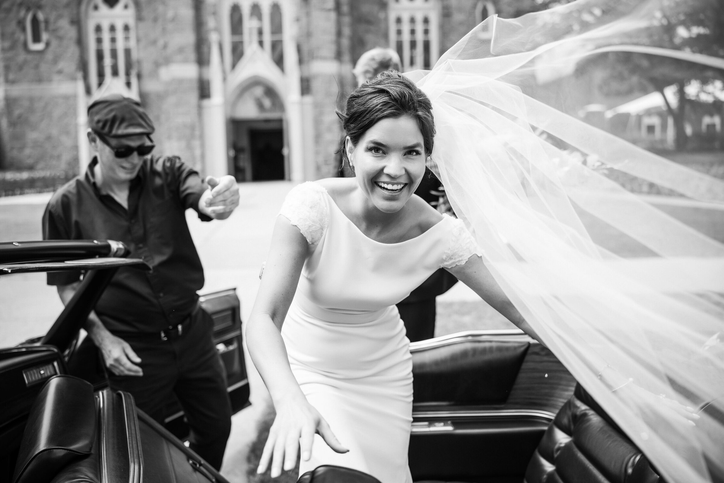 Stunning bride in a Pronovias gown is getting into the wedding car after the ceremony in Philadelphia
