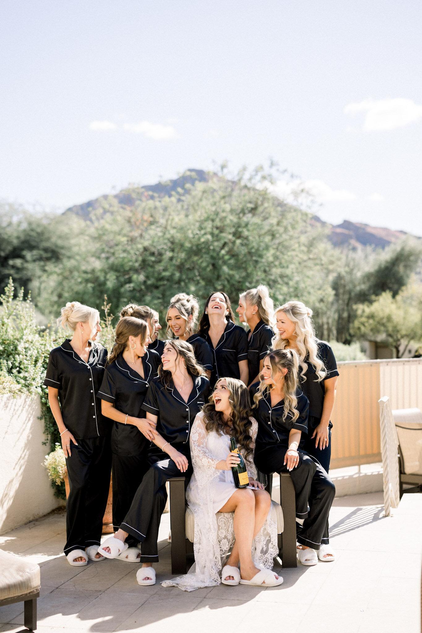 Bridal party getting ready as wedding photographer makes them laugh. 