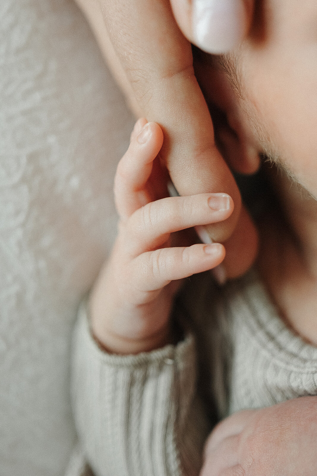 baby holding onto mums finger
