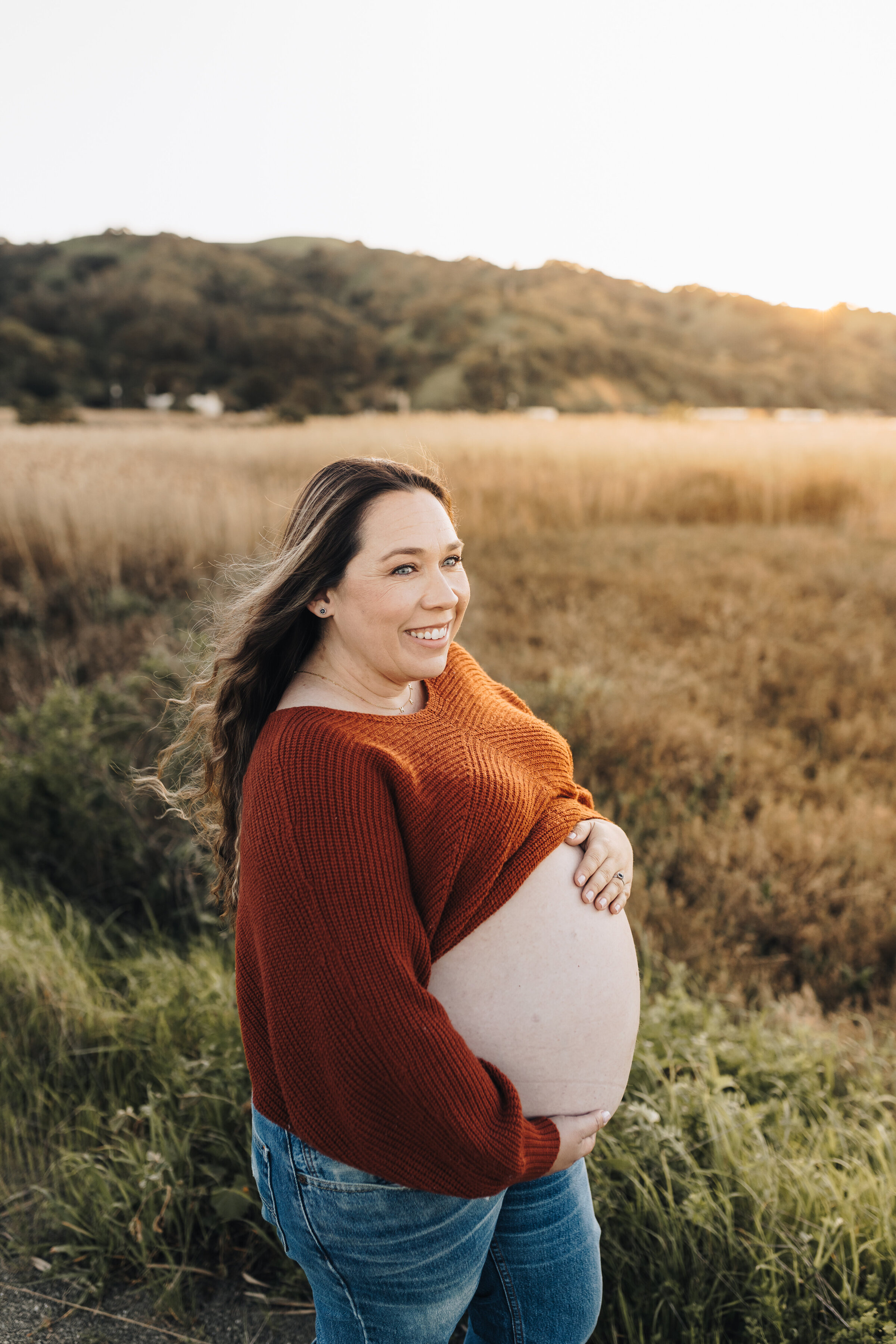 Pregnant mom shows her belly during a session at the Martinez Waterfront