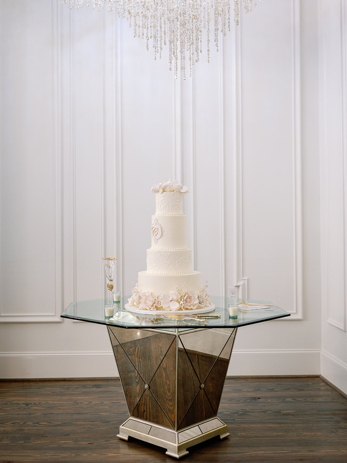 Four tier white wedding cake on a mercury glass table