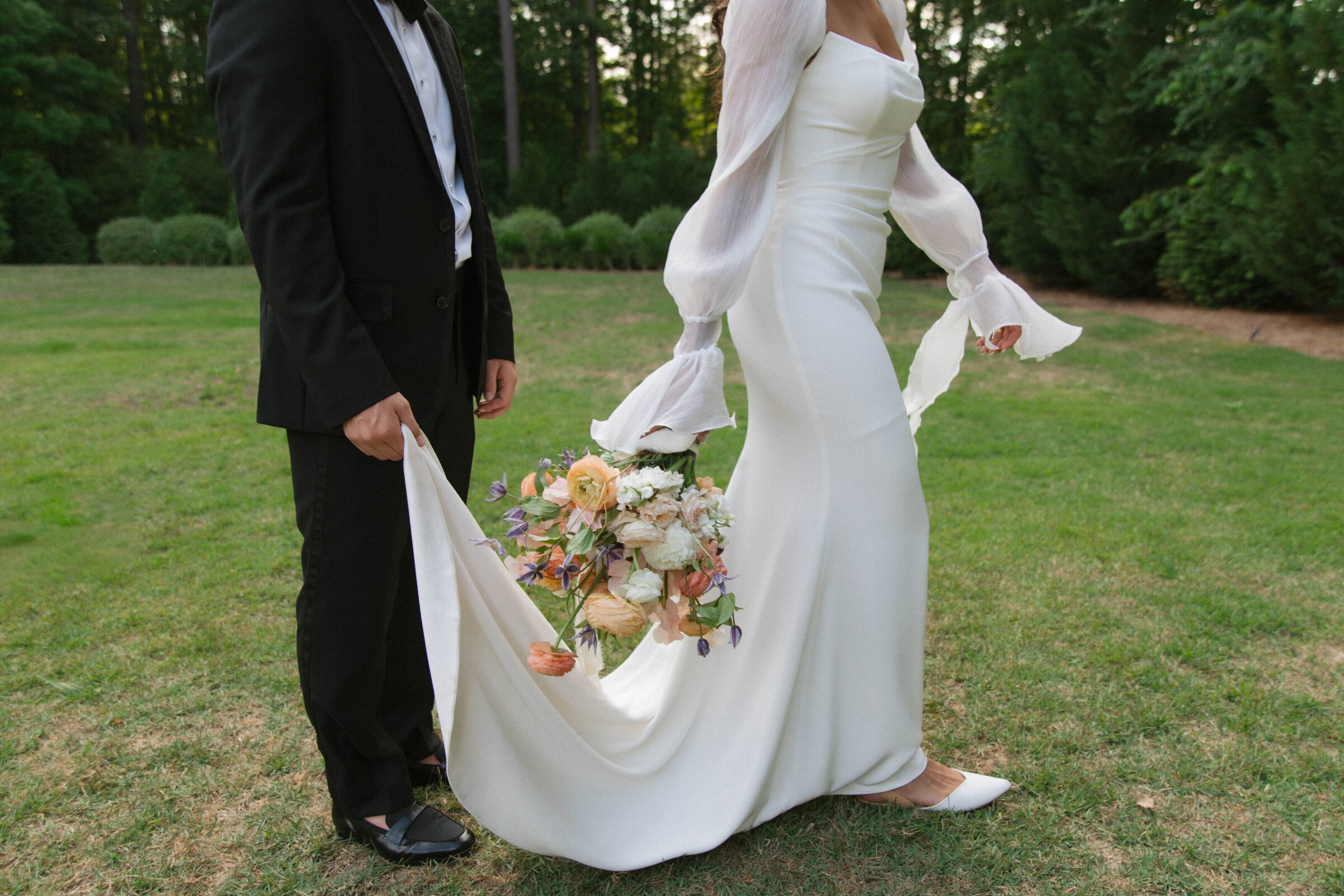 photo of bride and groom walking with florals