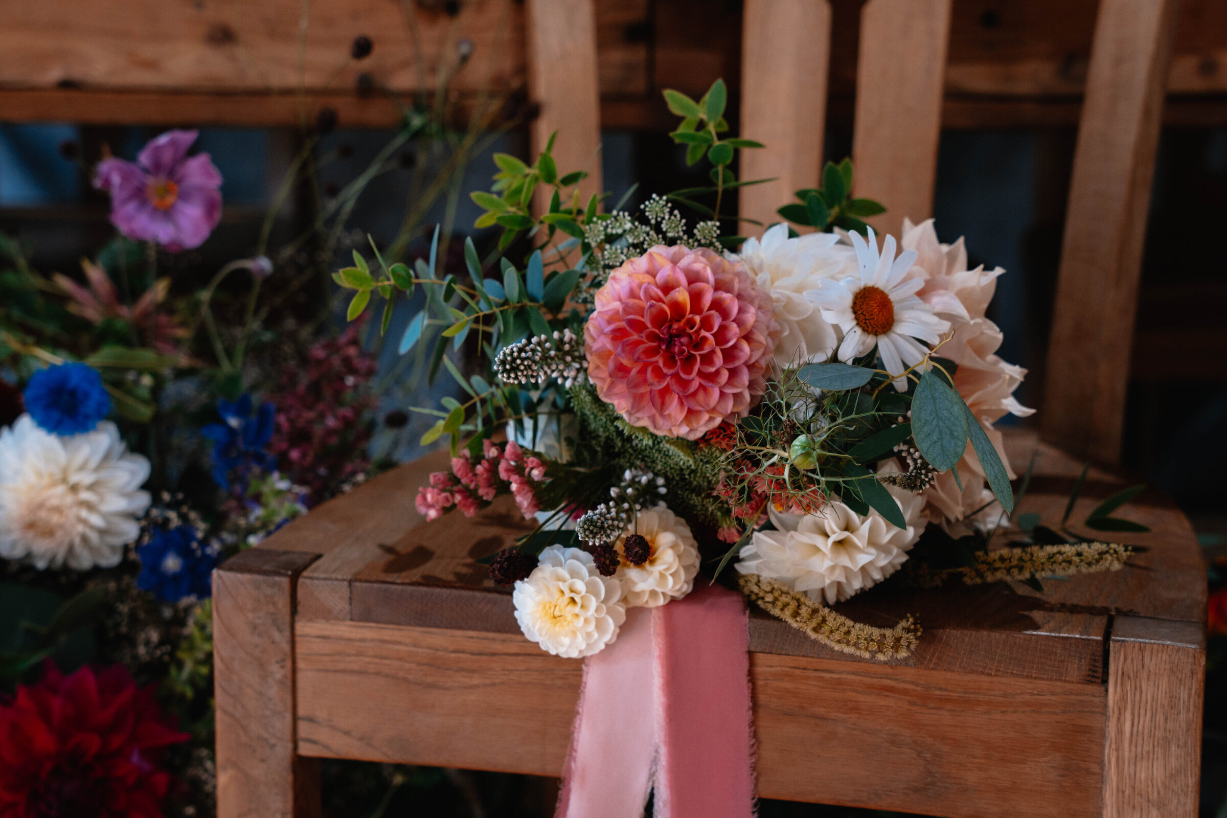 Bridal bouquet of a variety of flowers placed on a wooden chair
