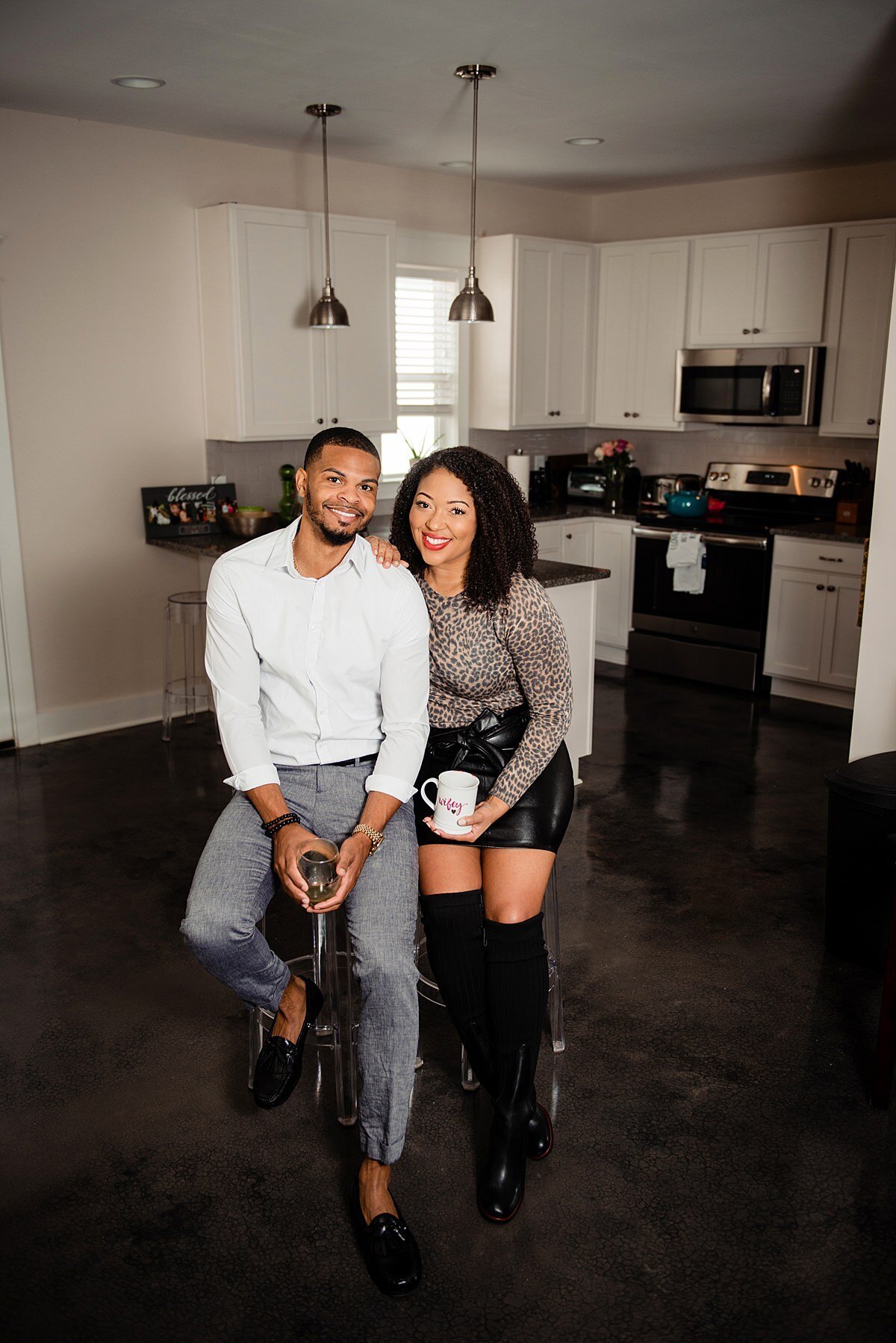 Indoor photoshoot in couples new home in East Nashville, newlyweds smiling at camera in their new kitchen