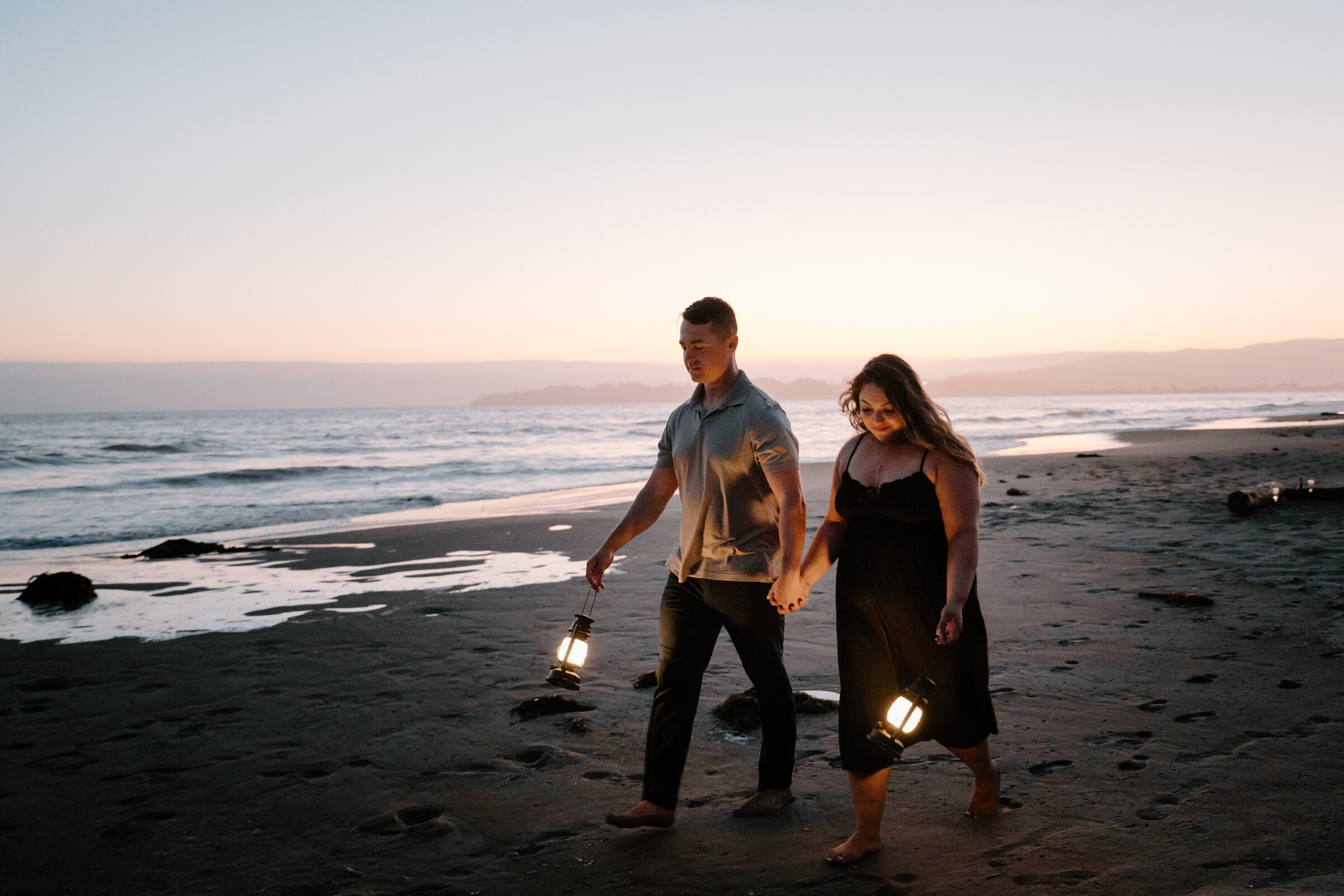 Beachside engagement session with lanterns at blue hour with rich colors and moody tone