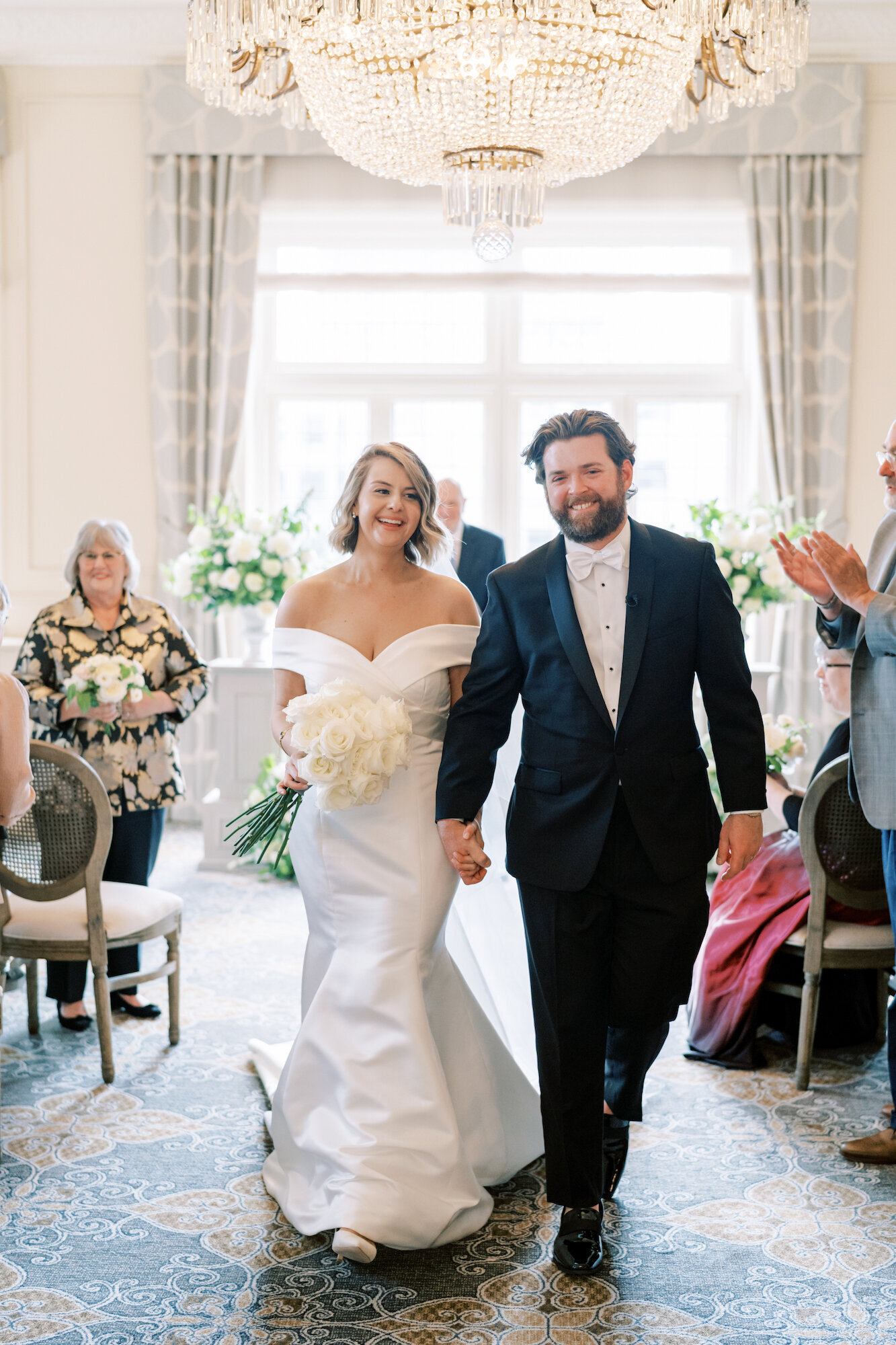 bride and groom walking down the aisle on historic blue carpet indoors