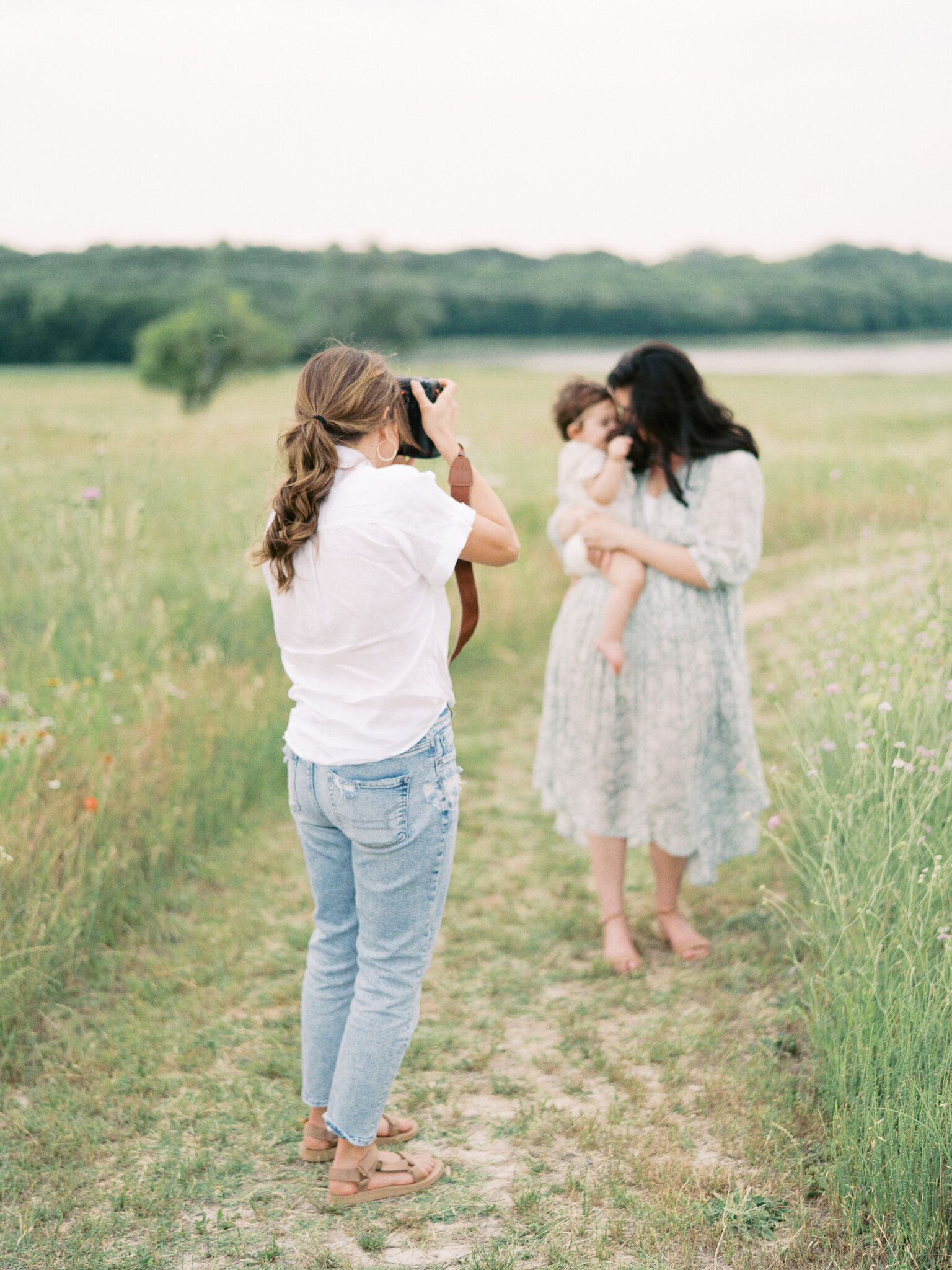 Little Rock photographer Bailey Feeler takes photograph of brunette mother snuggling young daughter in field