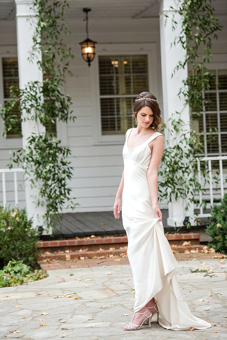 Bride wearing satin slim fitting dress posing outside of the main house at Cedarwood Weddings