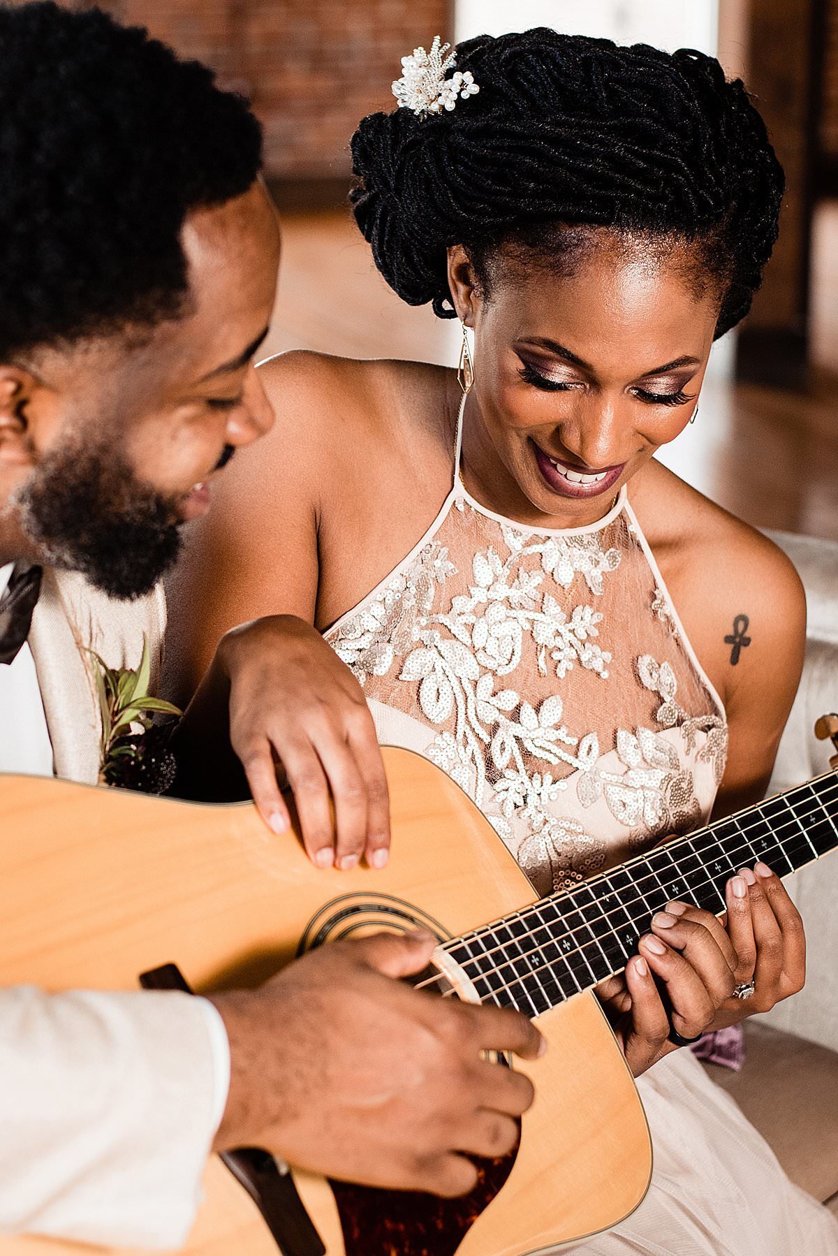 Couple playing guitar together on their wedding day