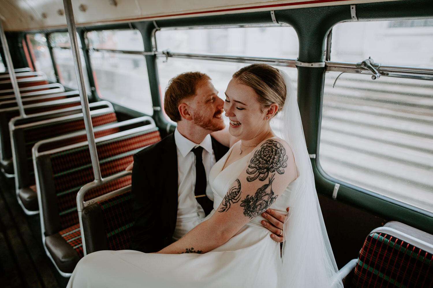 Wedding couple sit on a vintage bus outside Marylebone Town Hall in London.