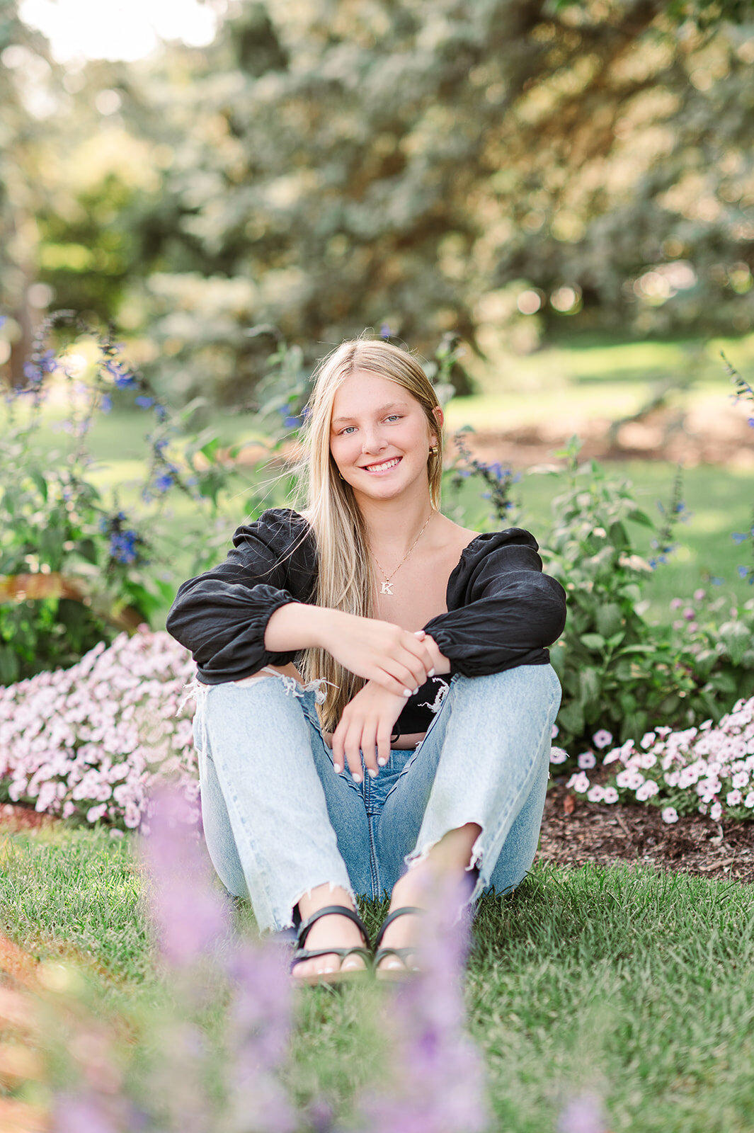 High school senior smiling in a flower garden during mini session in Baltimore, MD