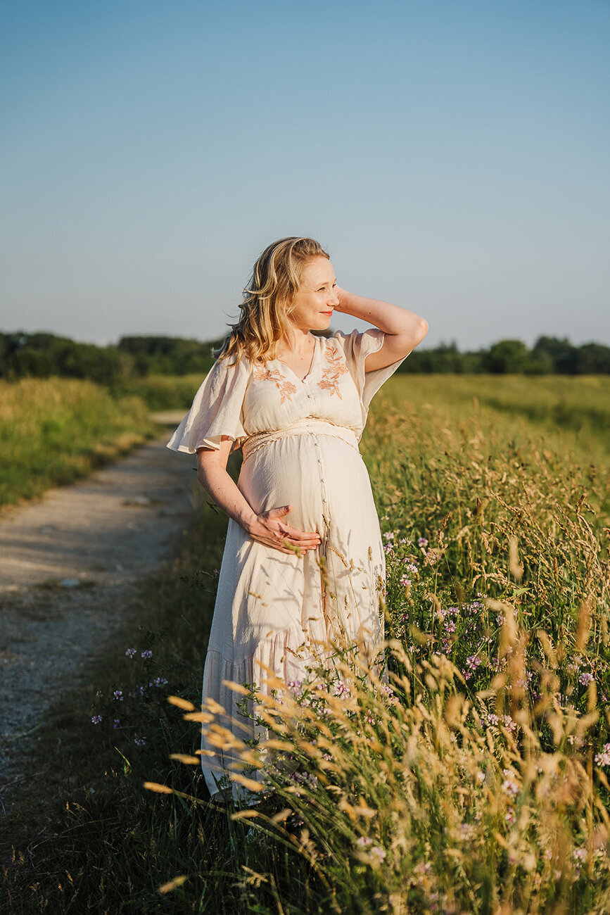 portrait of pregnant mother in field at sunset