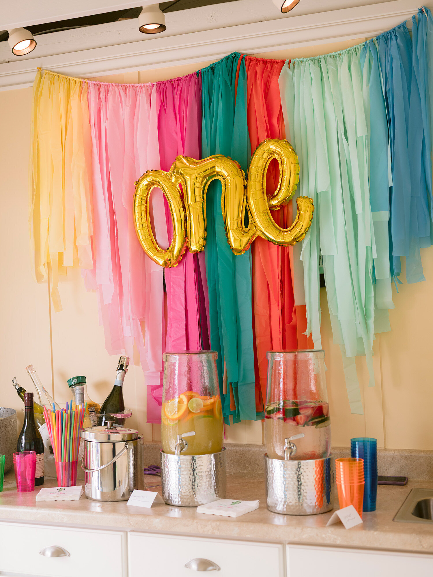 Bay Area first birthday party photographer captures a bright and colorful wall with the word "ONE" as part of the party decorations