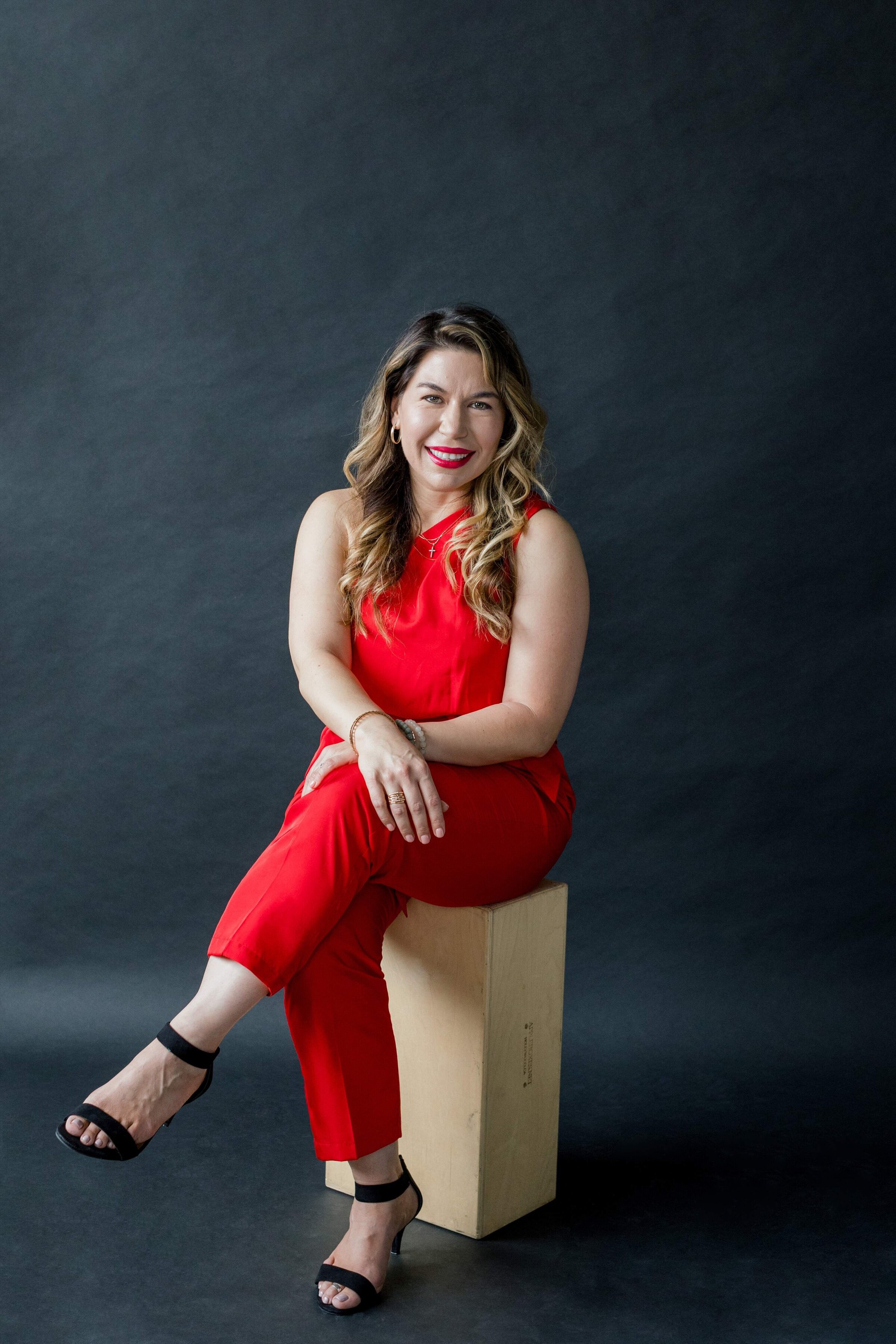 Nickie Kehoe in Red Jumpsuit Smiling