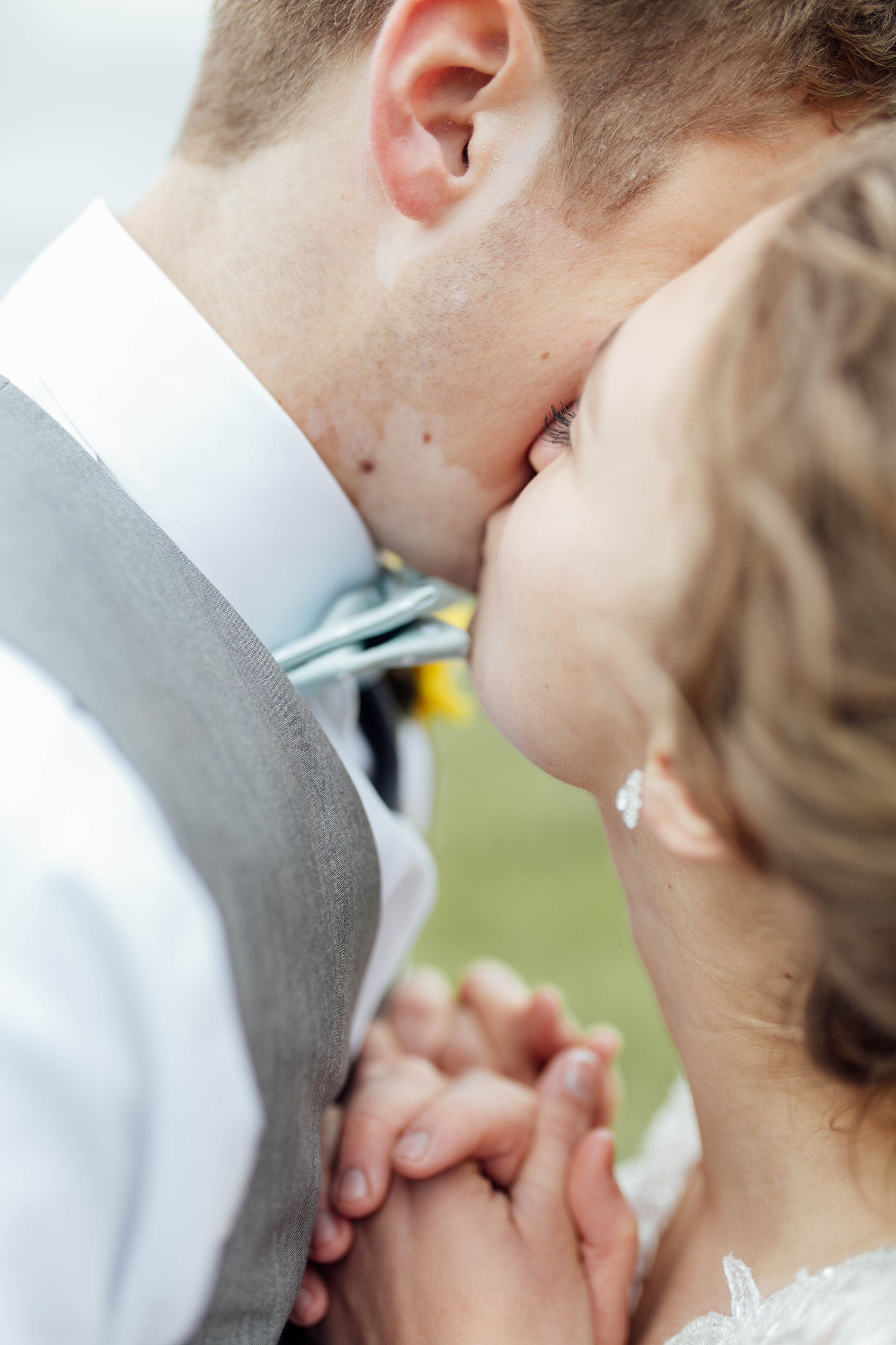 Bride kissing groom on cheek. 