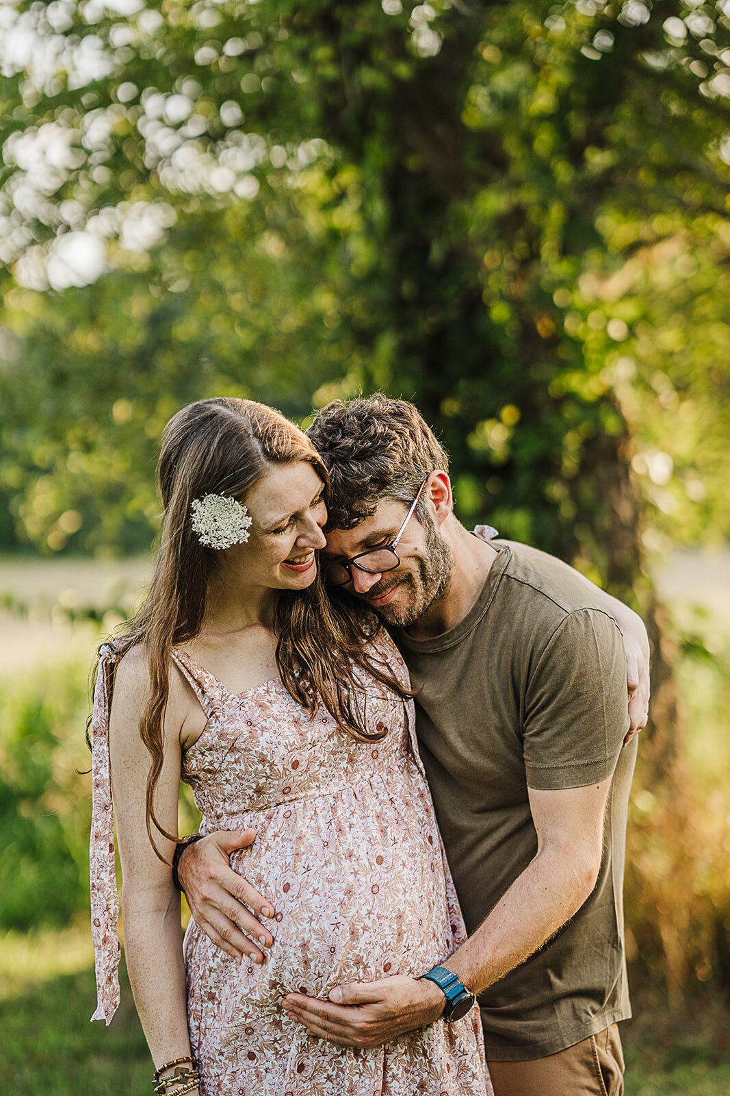 husband and wife snuggle during sunset outdoor pregnancy photoshoot in boston