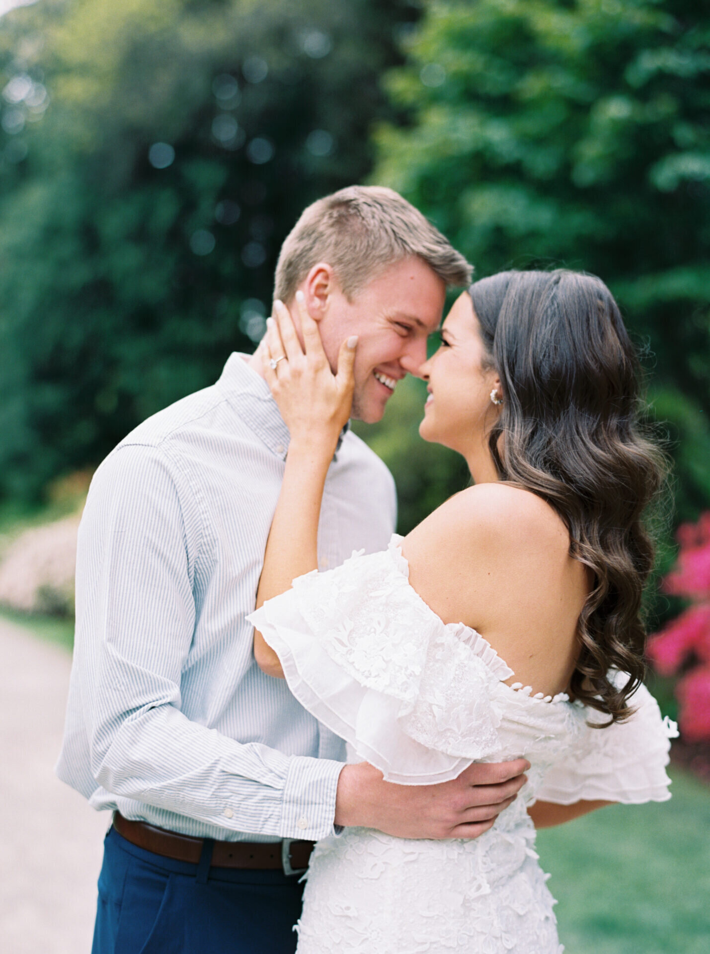 woman touching her fiances face as they smile close together