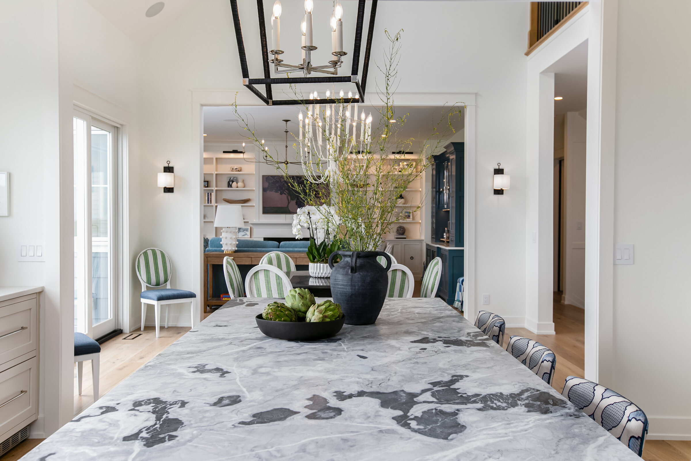 A stylish kitchen island with bar stools, offering a view into a more formal seating area. The design seamlessly blends casual and formal spaces, creating an inviting and versatile environment for both cooking and entertaining.