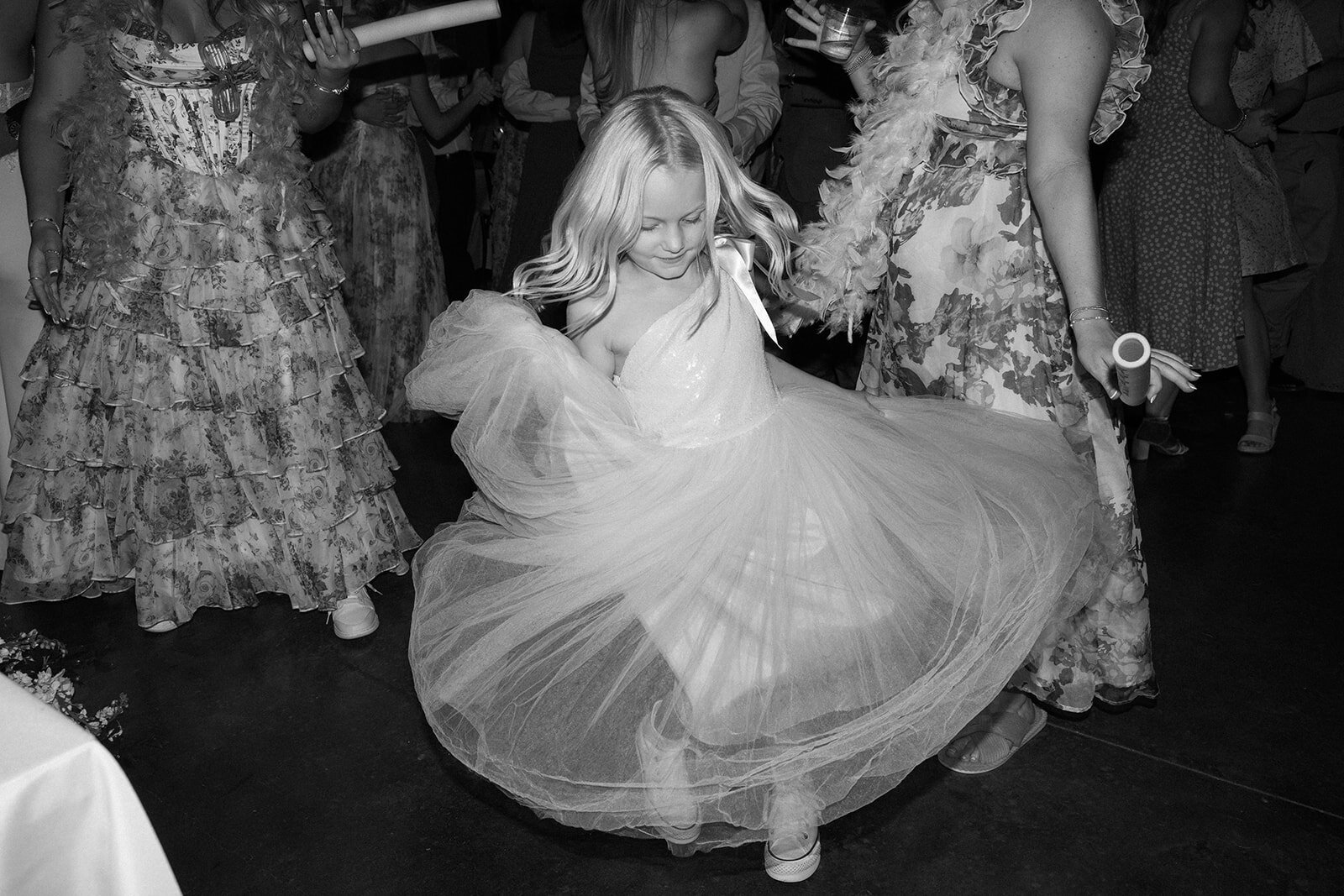 A flower girl dancing at the wedding reception.
