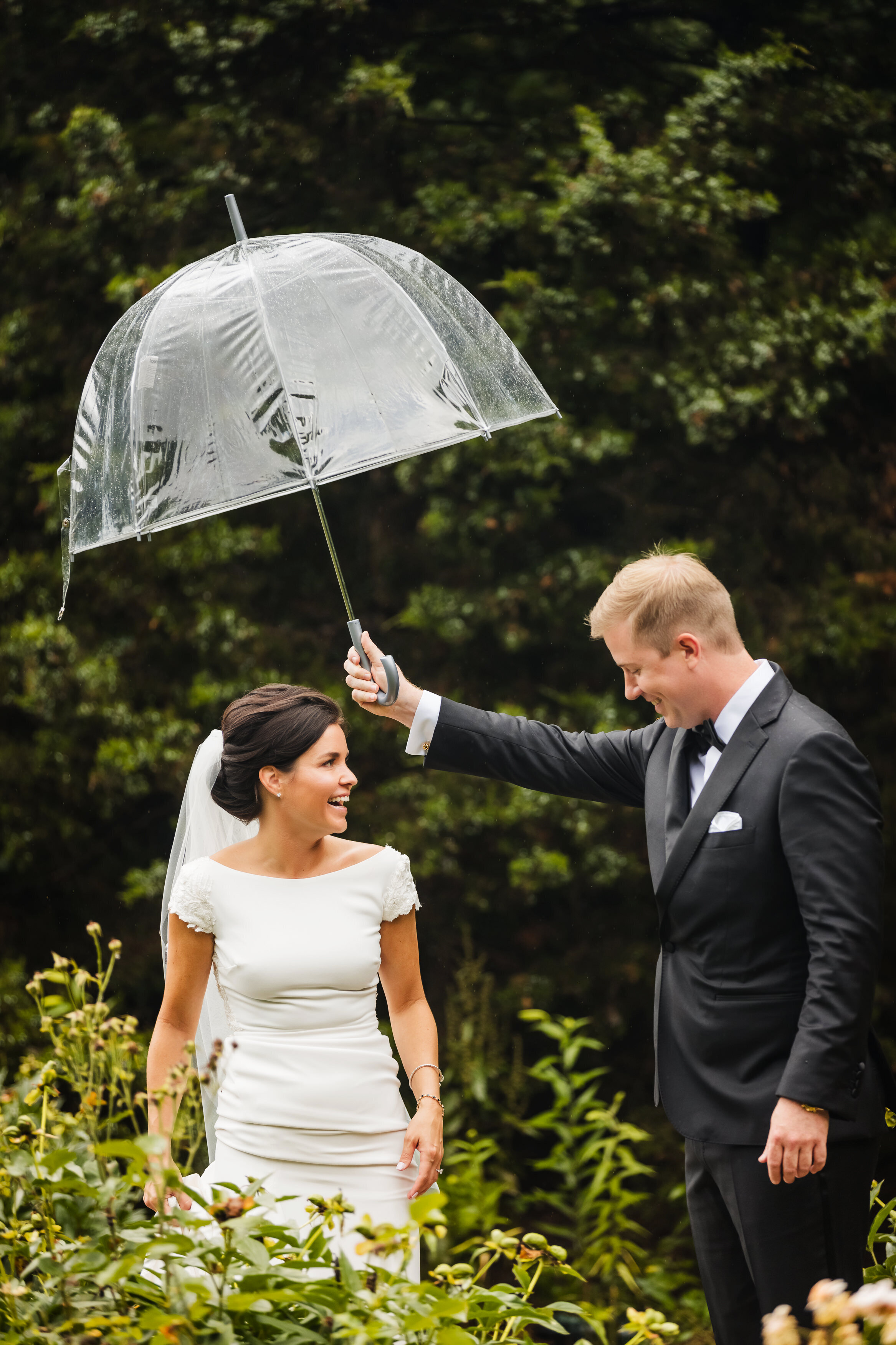 Bride and groom seeing each other for the first time on their rainy wedding  in Philadelphia, holding an umbrella
