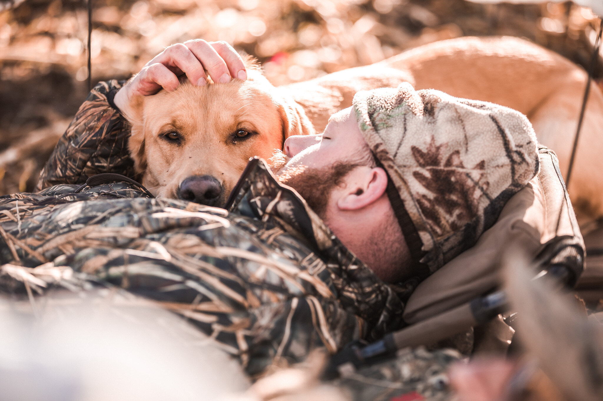 Hunter petting his dog in Kansas hunting blind