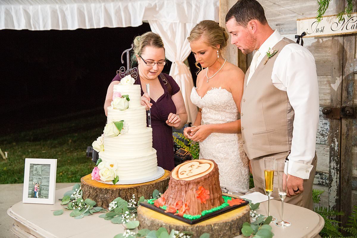 Mahlia showing bride and groom the best way to cut their wedding cake