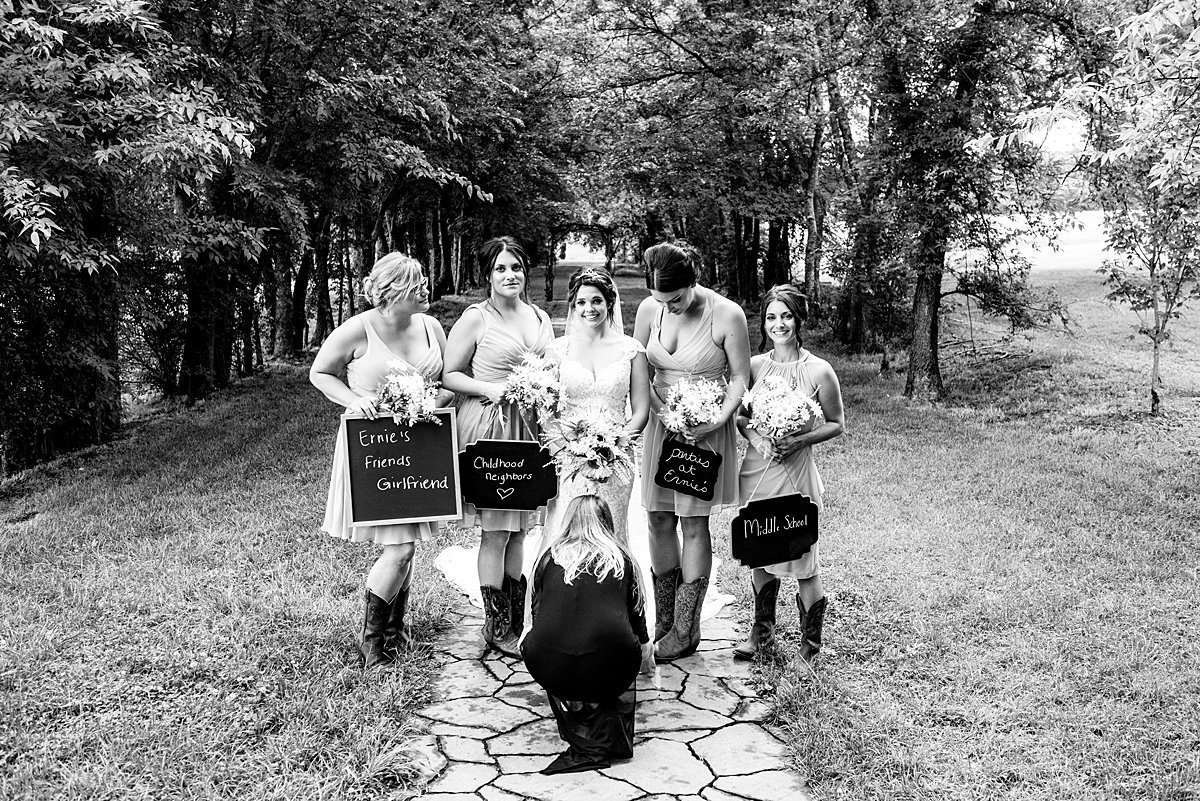 Black and White photo of photography assistant helping bridesmaids at lovers lane at Grace Valley Farm