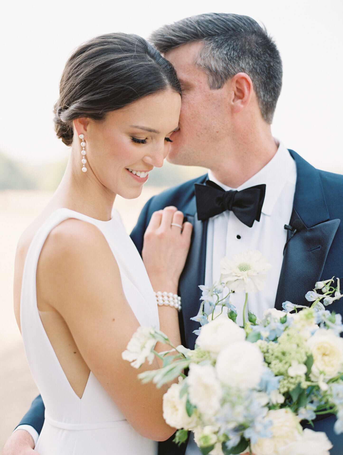 groom whispering in brides ear as she smiles