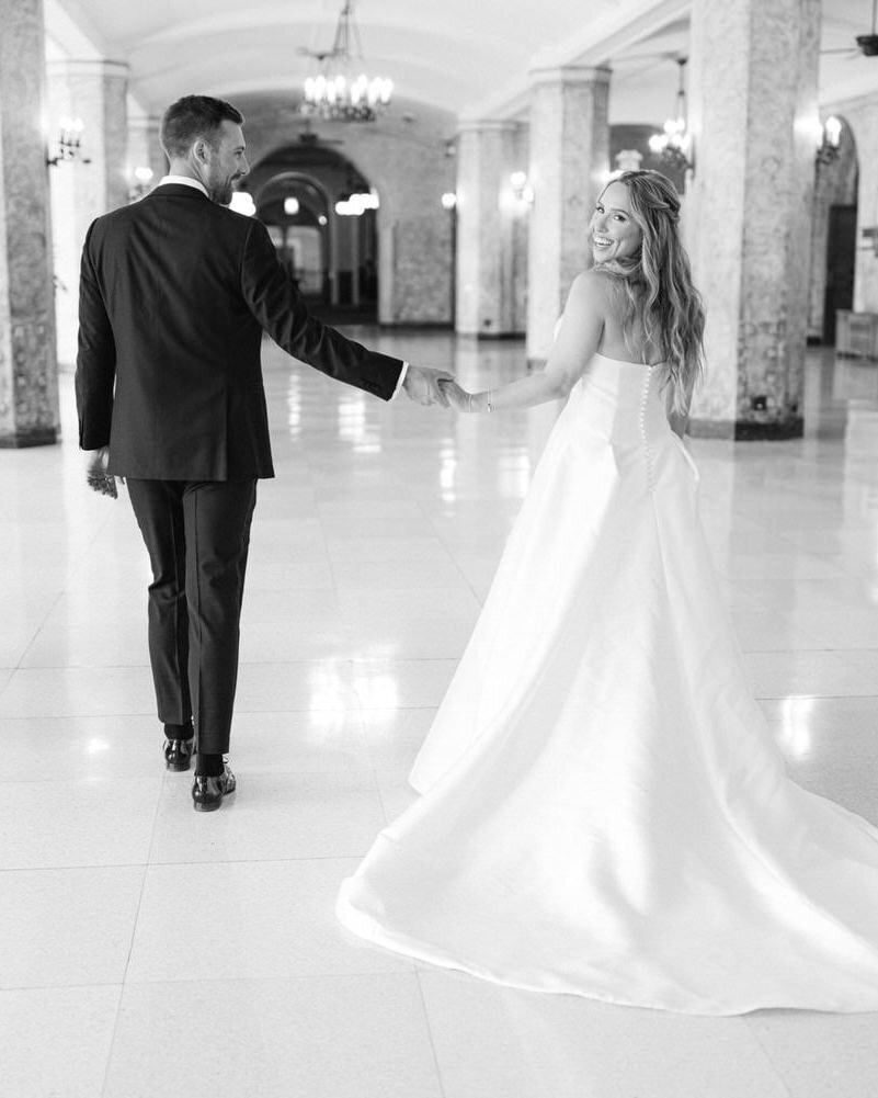 This joyful image captures the bride and groom walking hand in hand through the elegant halls of the Banff Springs Hotel, laughing with joy after their first look. The historic venue adds a touch of grandeur to this heartfelt moment of shared excitement.