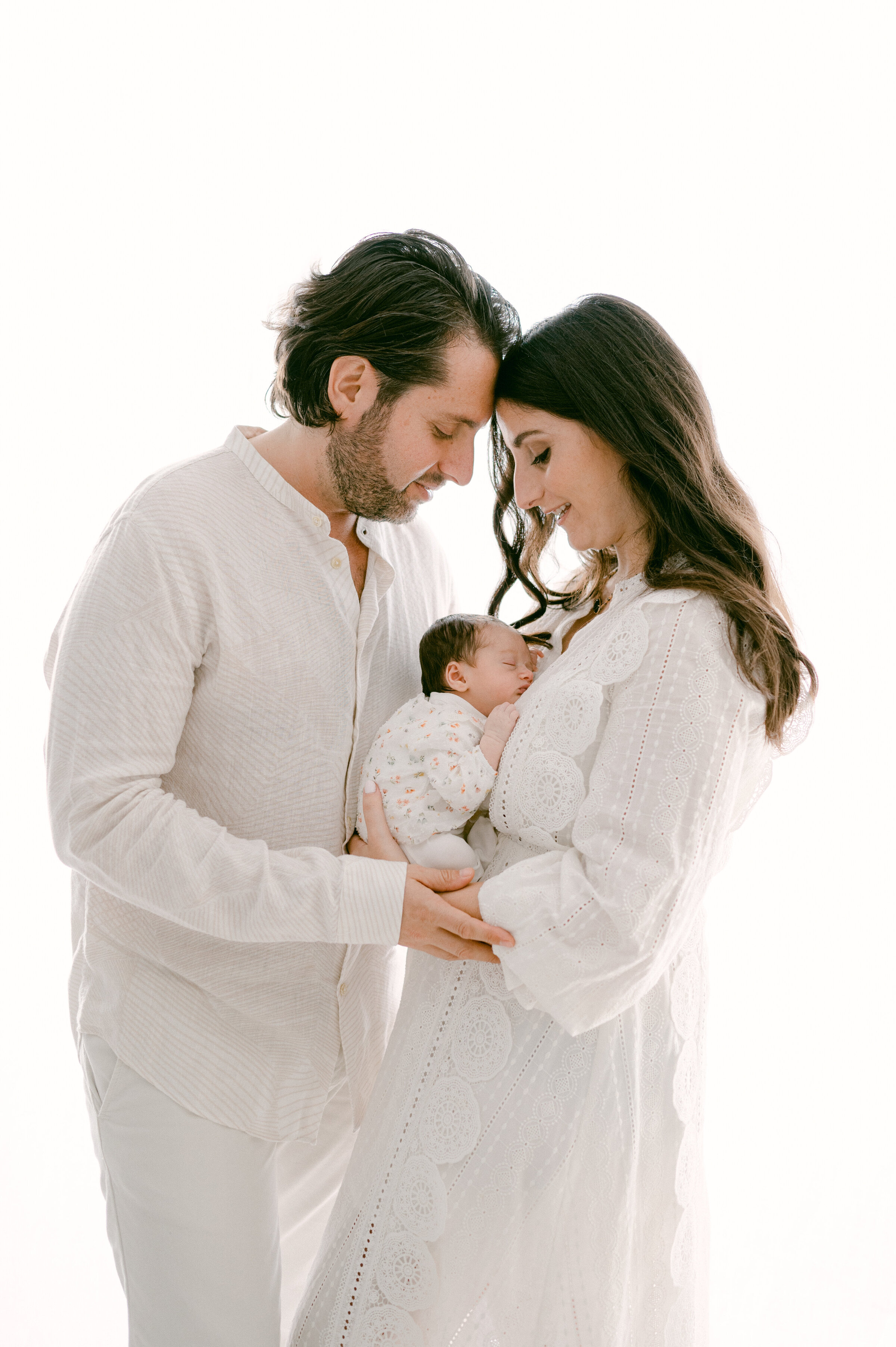 Dad and mom holding their newborn baby by Miami Newborn Photographer