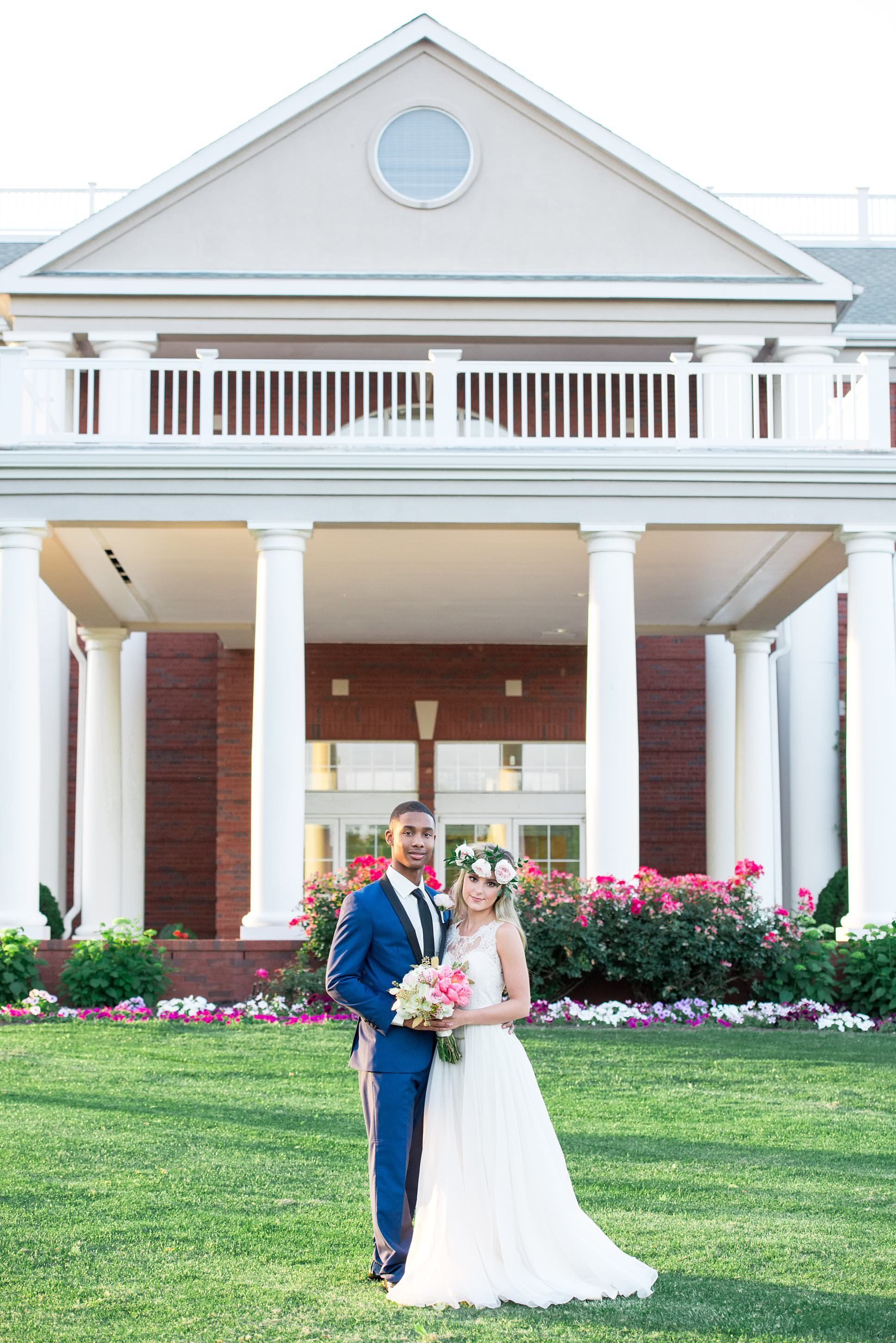 Couple standing outside of Stones River Country Club on a bright summer day