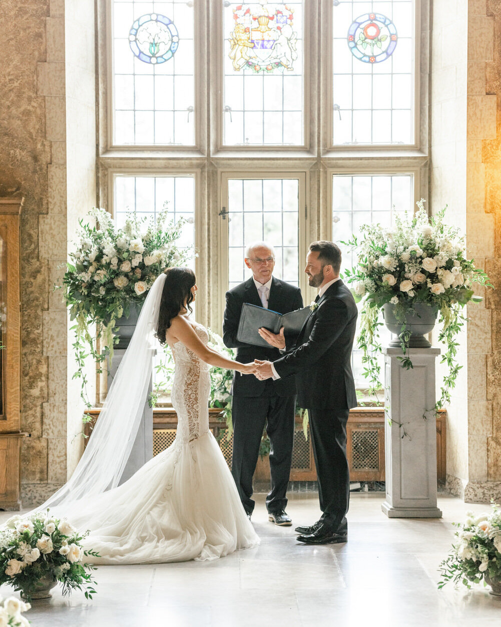 This elegant image captures the bride and groom exchanging a meaningful glance during their ceremony in the stunning Mount Stephen Hall at Banff Springs. The grand architecture and historic ambiance provide a breathtaking backdrop for this intimate moment.
