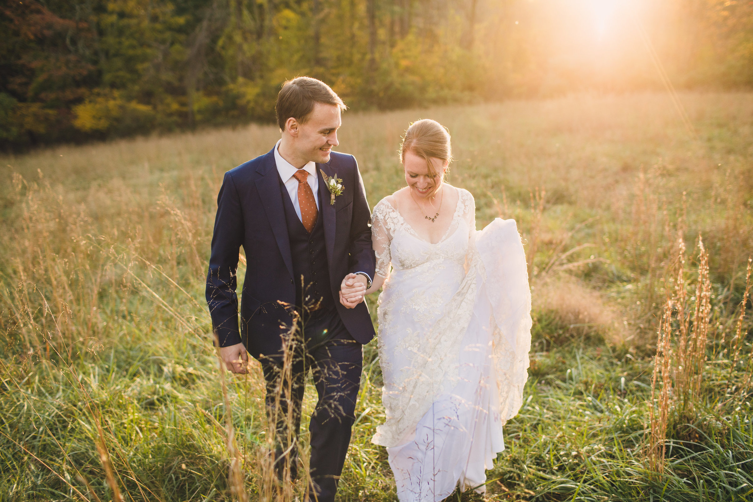 Bride and groom walking in field at Parque Ridley Creek wedding venue