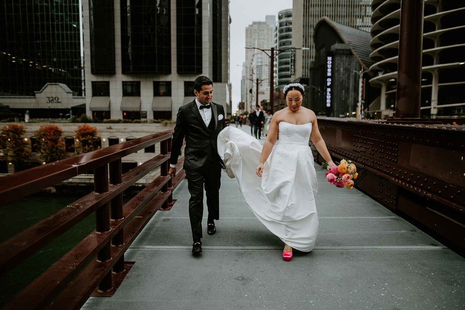 Wedding couple walking along Chicago bridge.