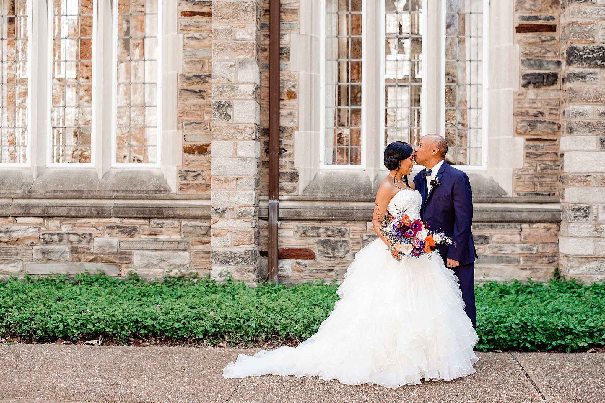 Newlywed couple standing on sidewalk in front of historic building on Scarritt Bennett campus