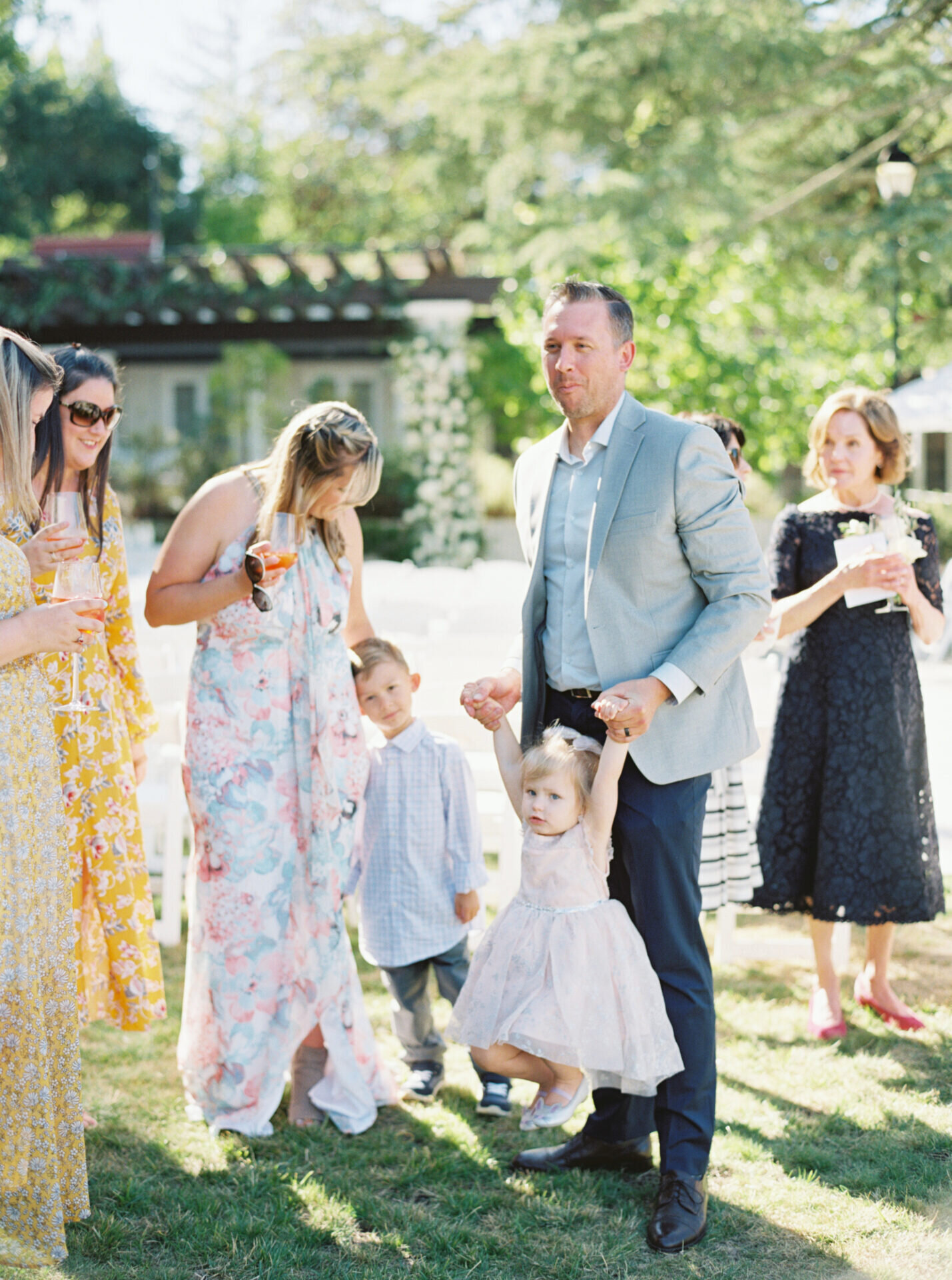 candid photo of wedding guests outside on grass