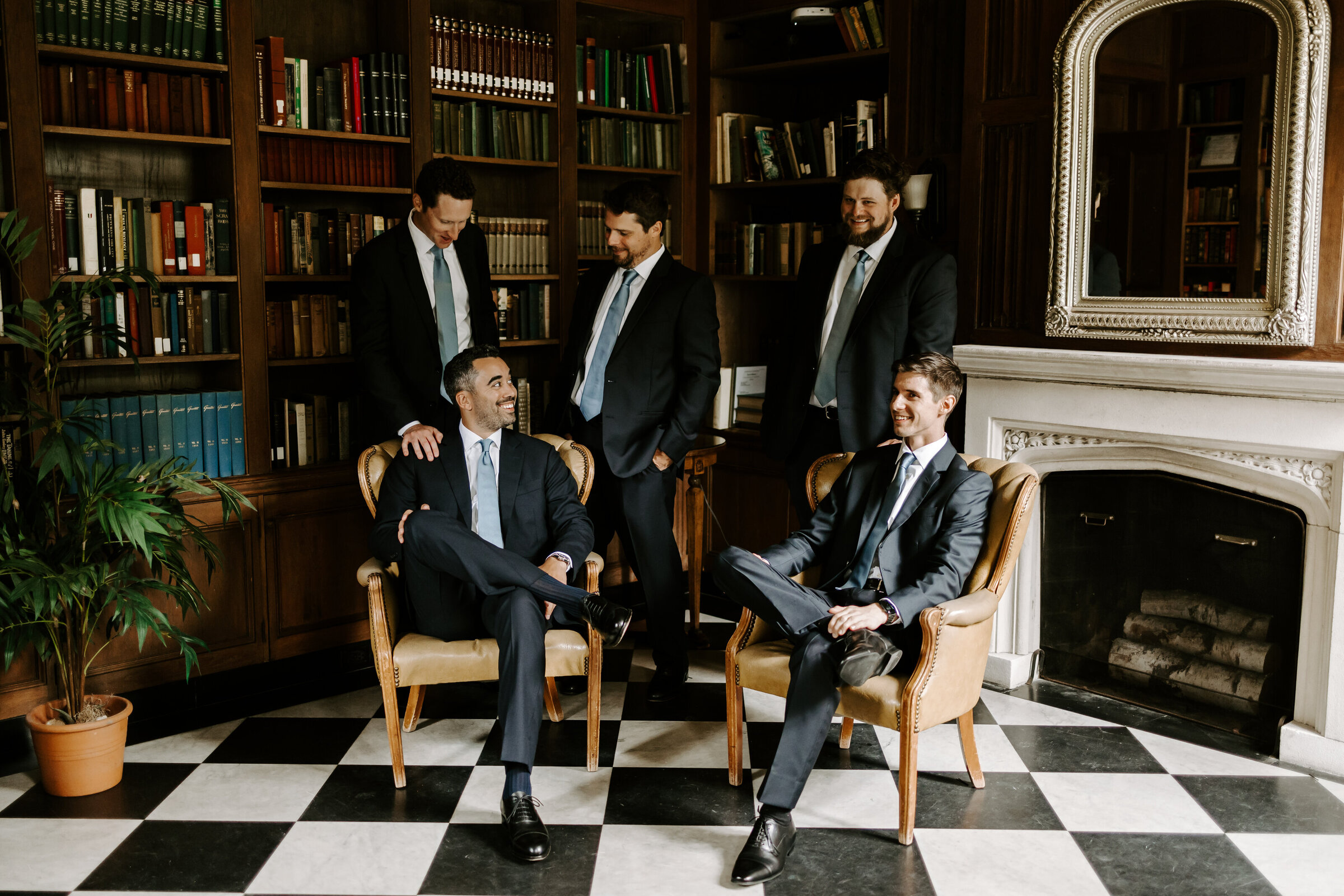Groom and his groomsmen sit casually in library at Misselwood Events at Endicott College
