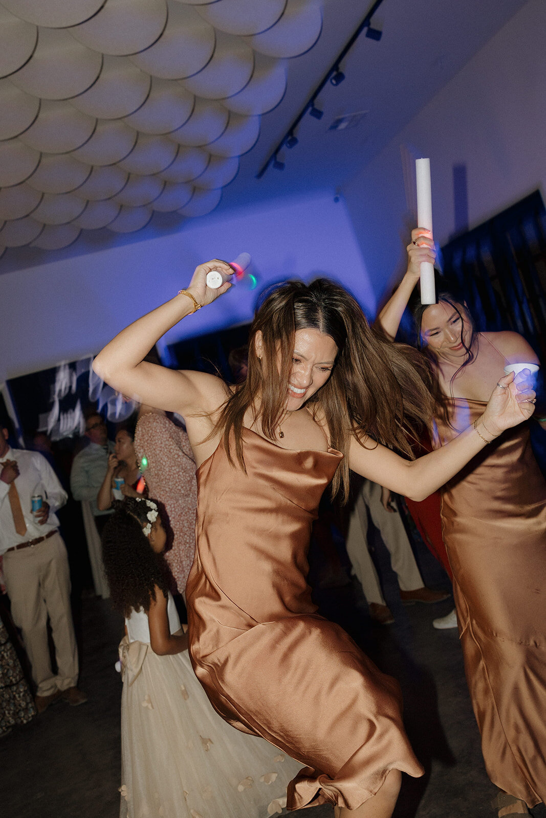 A guest dancing with a glow stick at the wedding reception at Lucky Arrow Retreat.