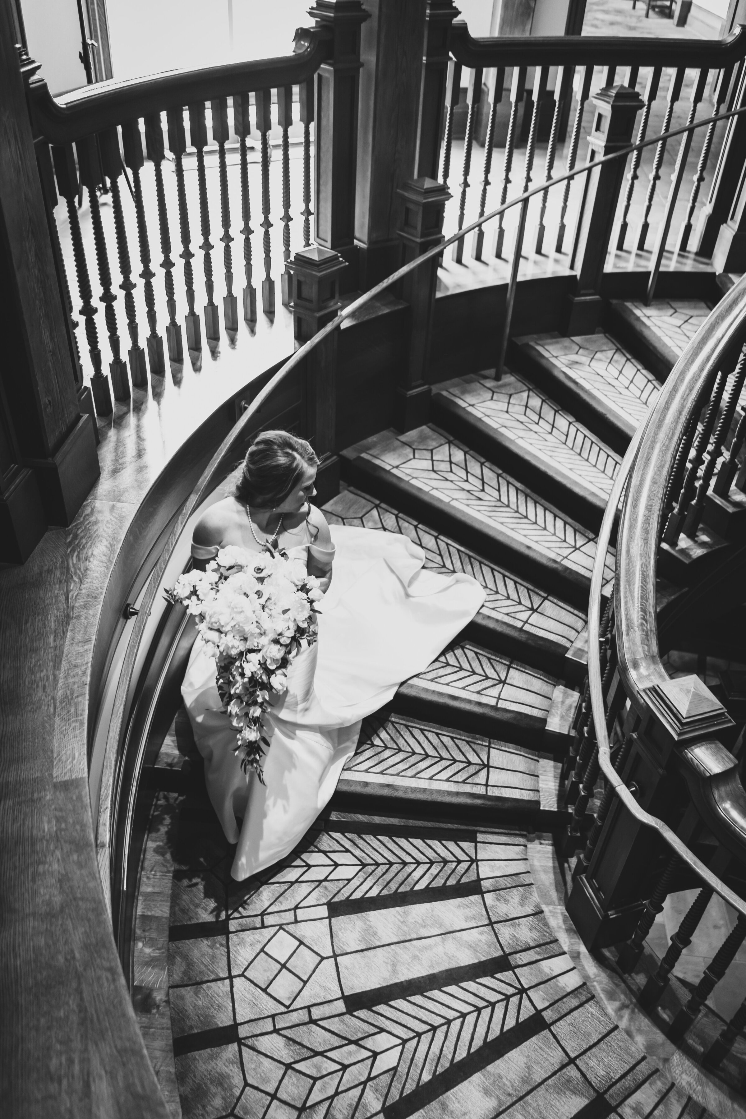 Bride looking over shoulder walking down stairs.