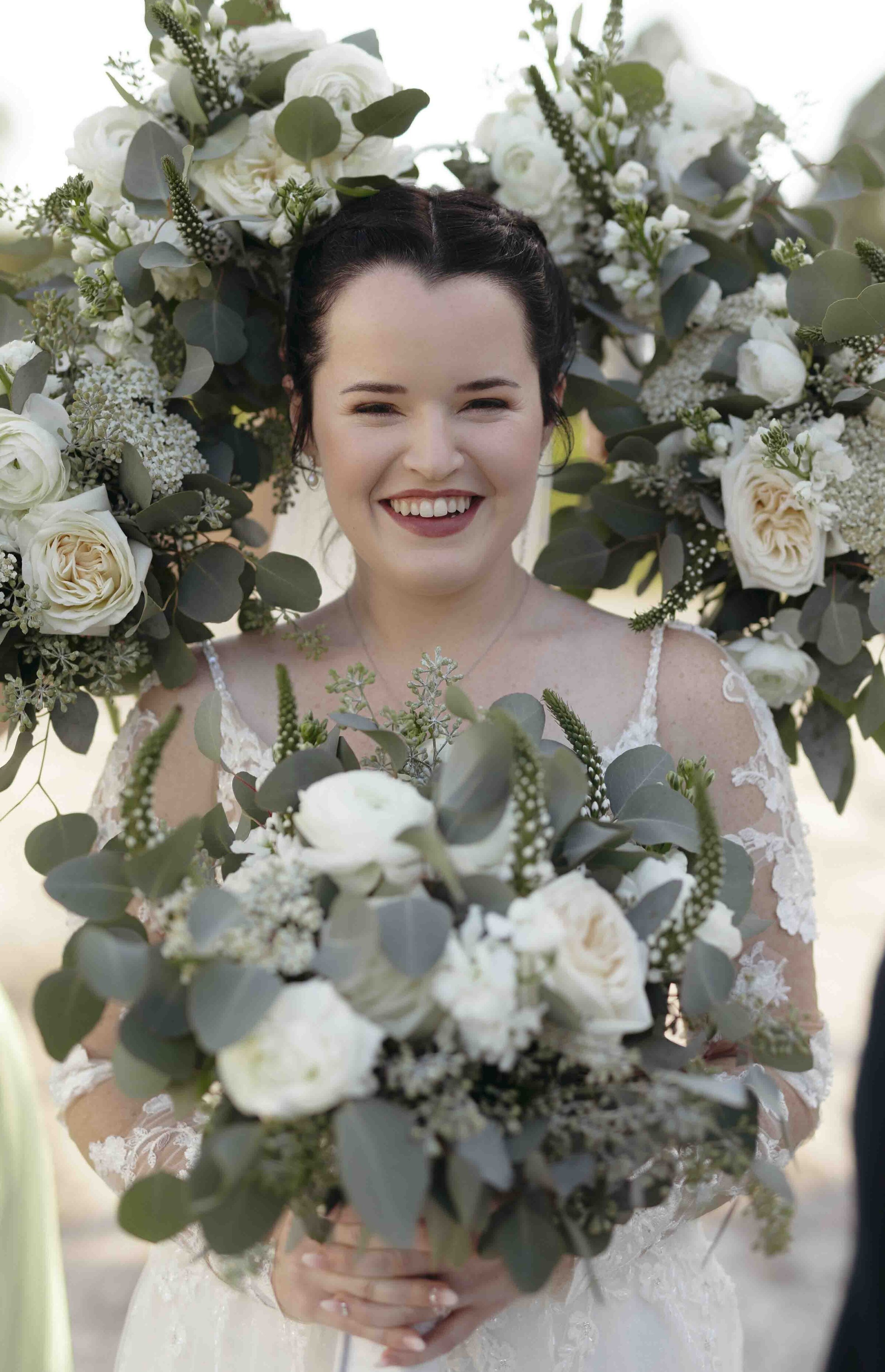 Bride smiling and holding a flower bouquet
