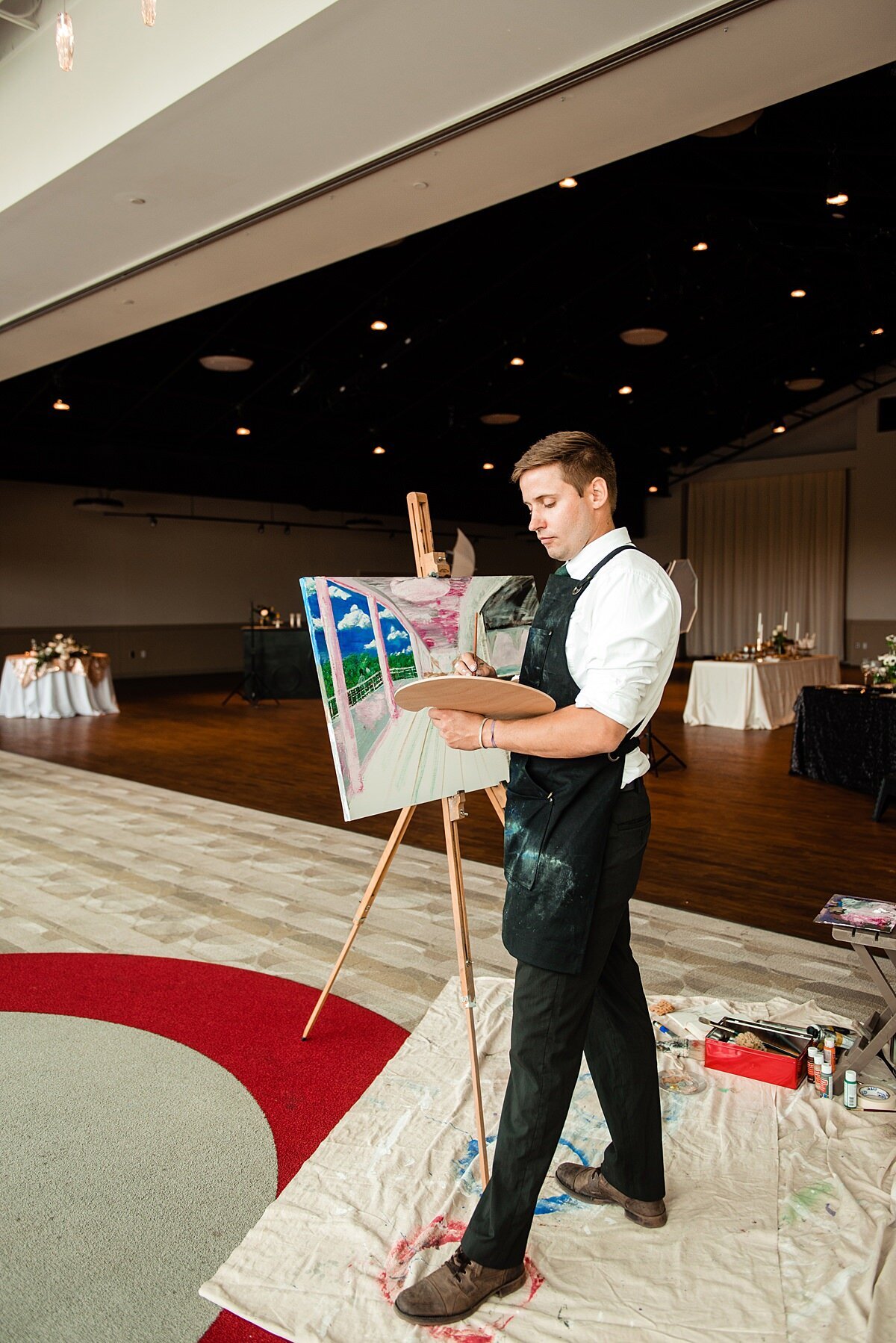 Live Event Painter working on a ceremony setting painting for a wedding at Noah Liff Opera Center
