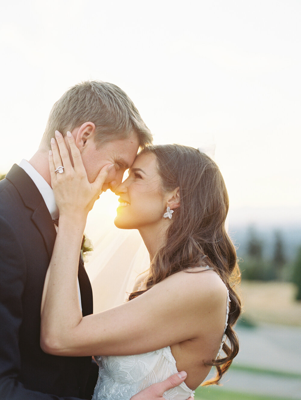 bride and groom foreheads touching in golden light