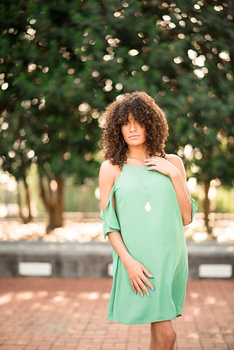 MTSU College Senior wearing a mint green dress modeling outside the Murfreesboro library