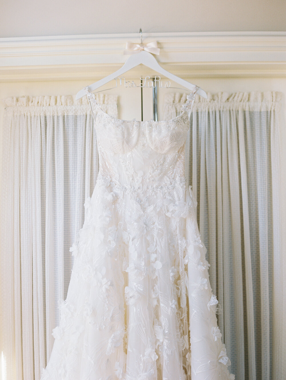 textured galia lahav wedding gown hanging on door at newcastle golf club