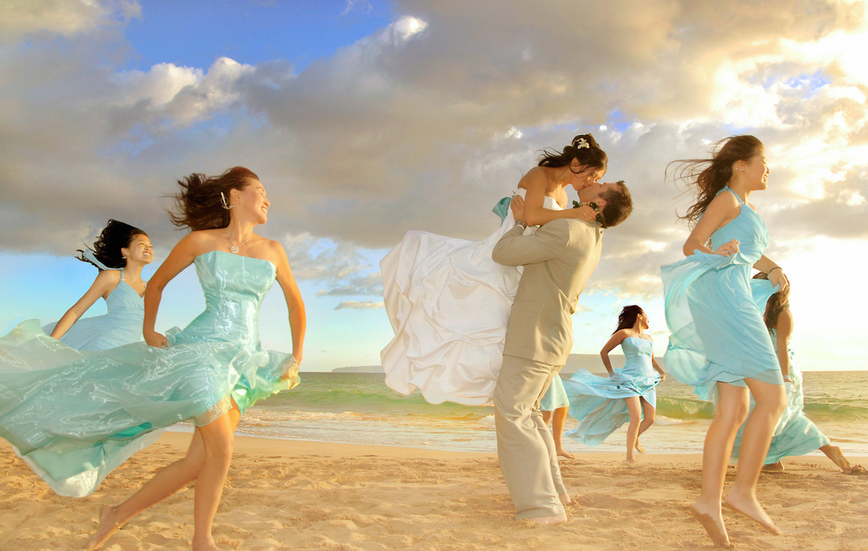 brides dancing around on the beach